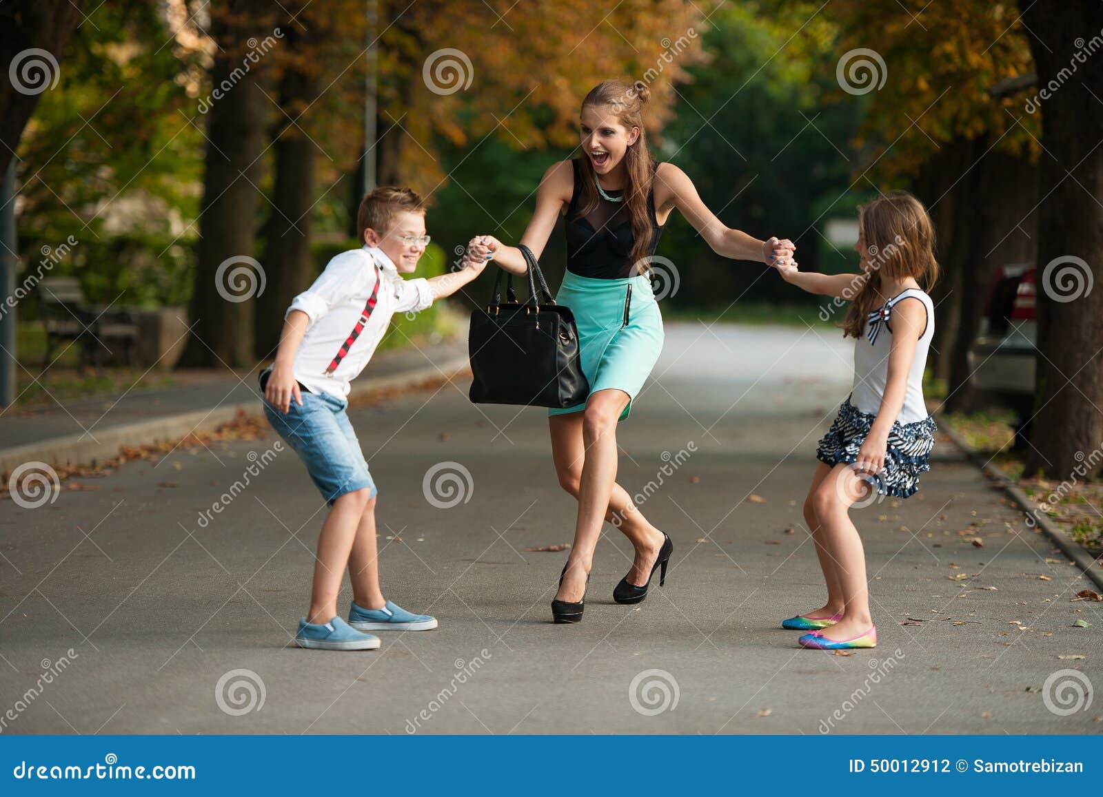 mother with naughty son adn daughter on a walk in park