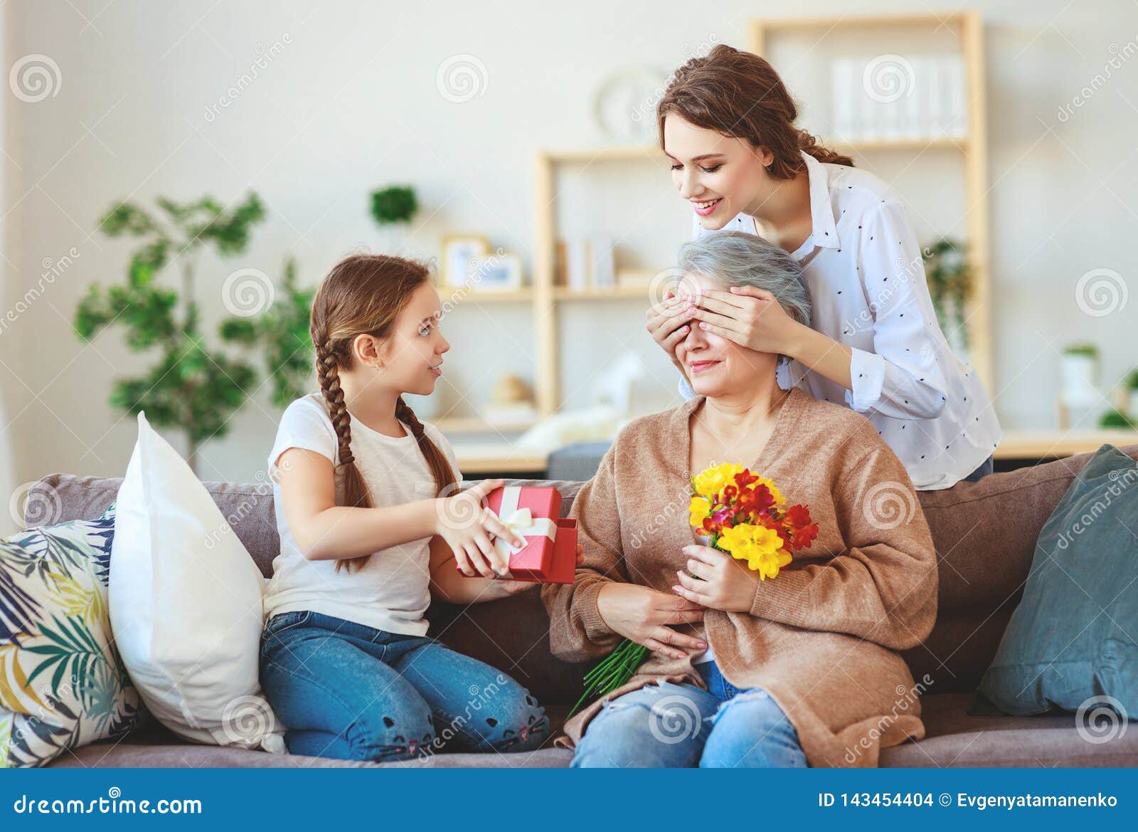 mother`s day! three generations of  family mother, grandmother and daughter congratulate on the holiday, give flowers