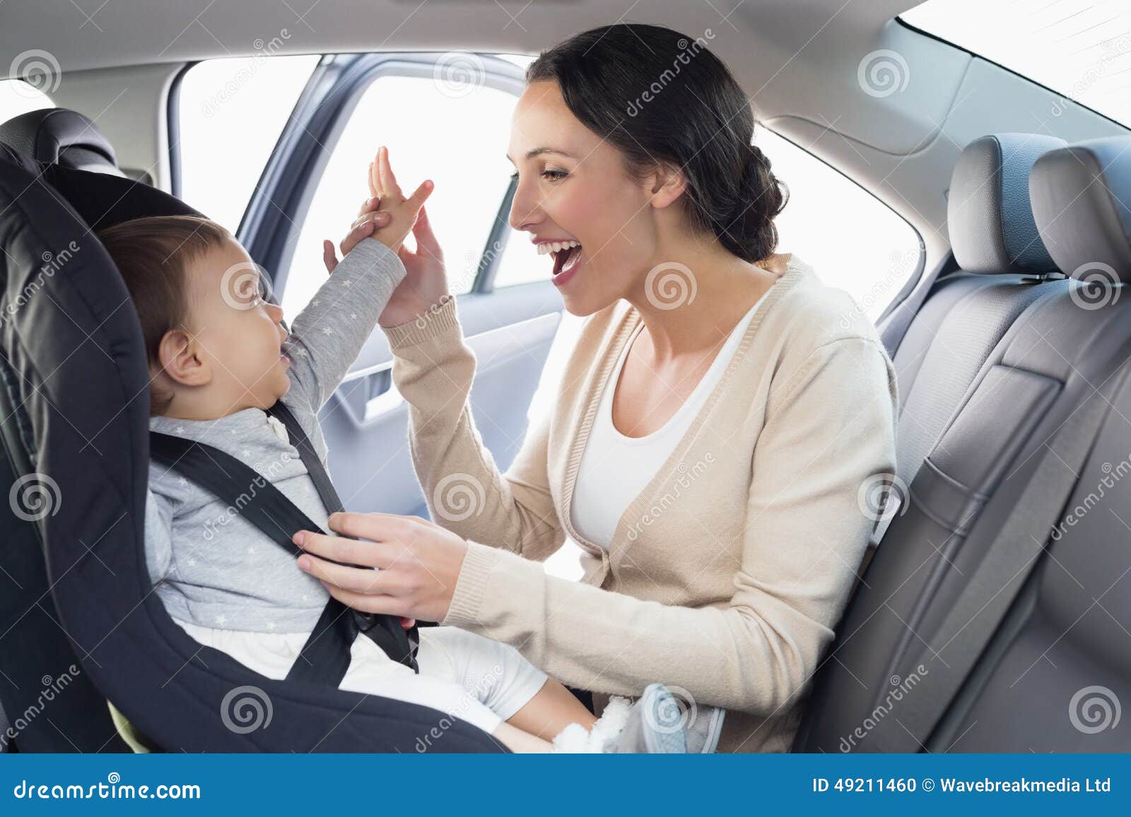 Mother Securing Her Baby in the Car Seat Stock Photo - Image of male