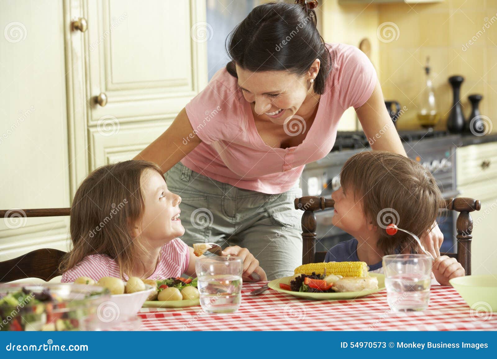 Mother Serving Meal To Children in Kitchen Stock Image Image of