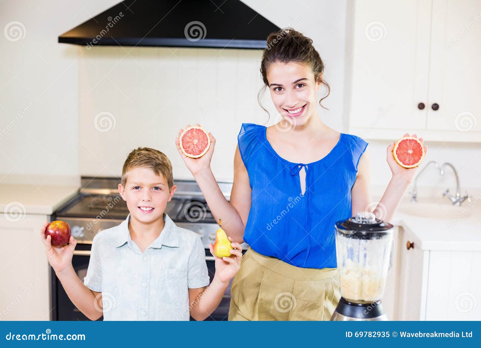 Mother And Son Holding Fruits In Kitchen Stock Image Image Of Bonding