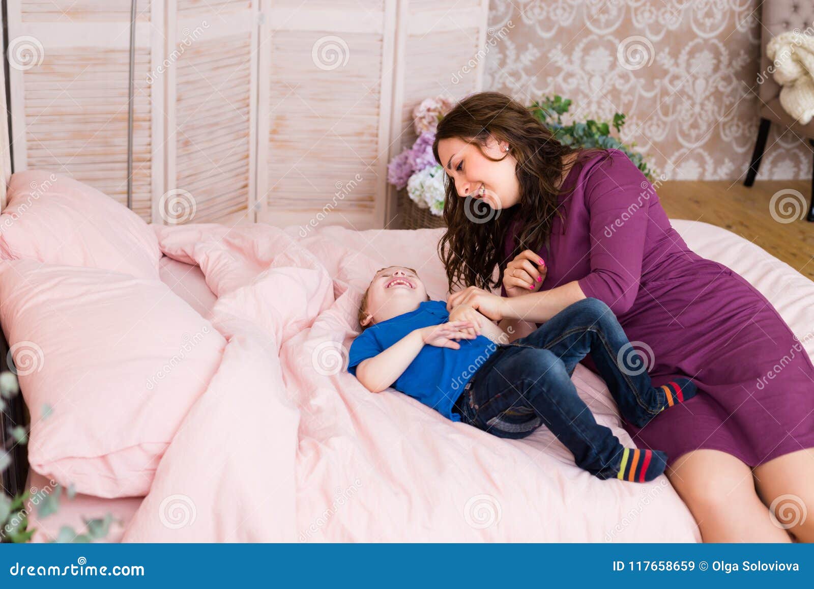 Little Boy Smiling And Playing With His Mom In The Bed Stock Image