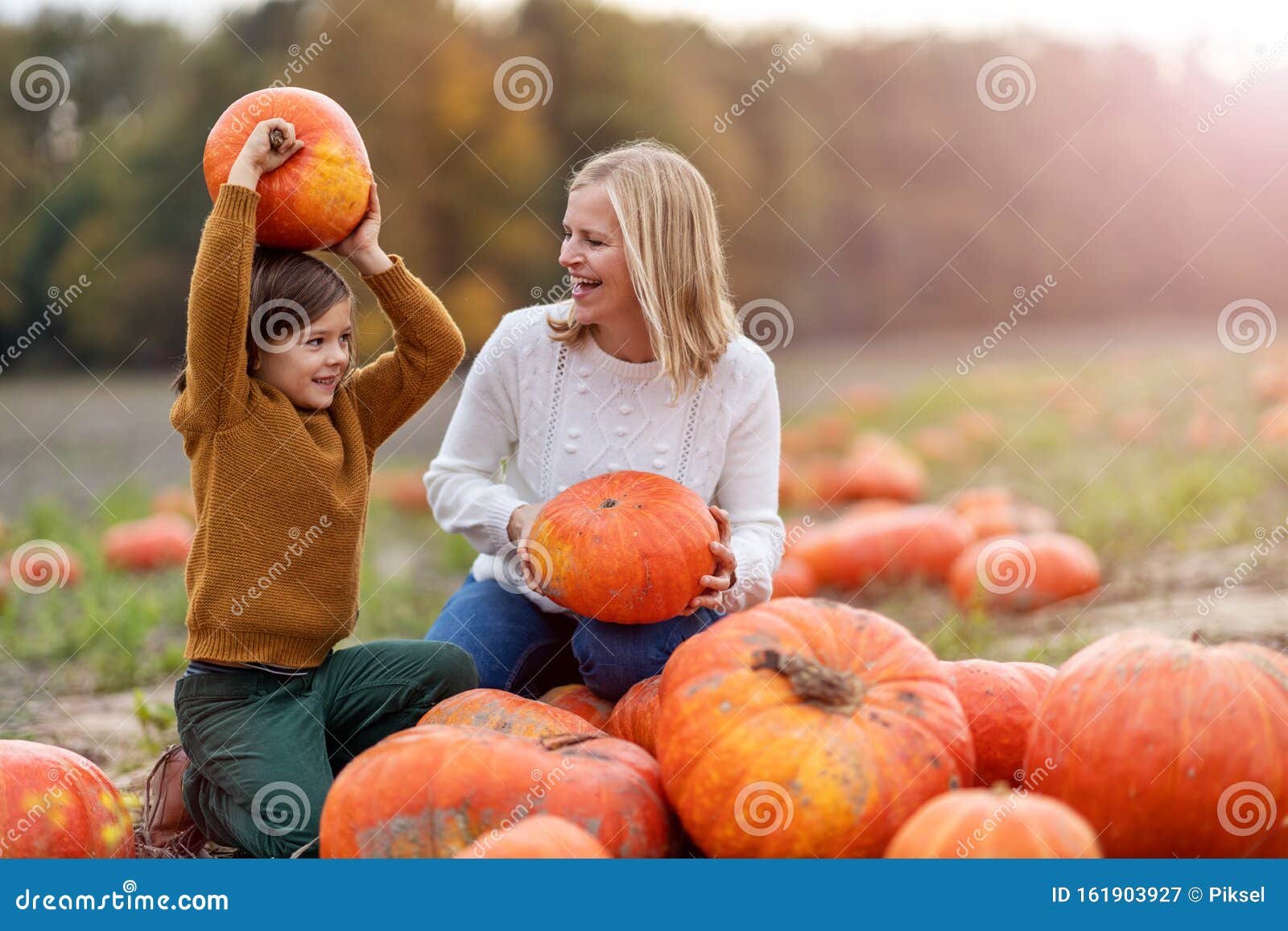 mother and son in pumpkin patch field