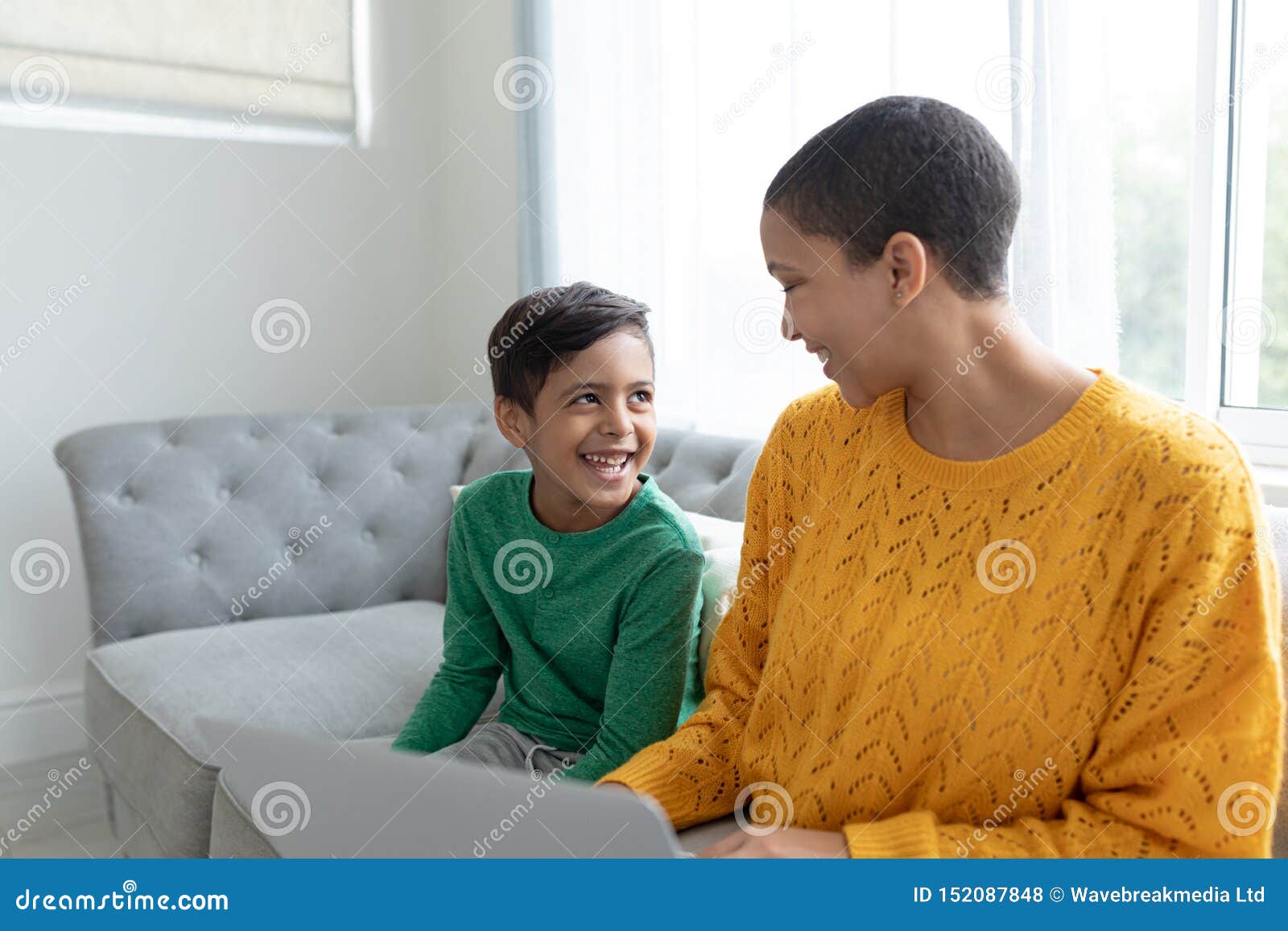 Mother And Son Using Laptop On A Sofa In Living Room Stock Ph