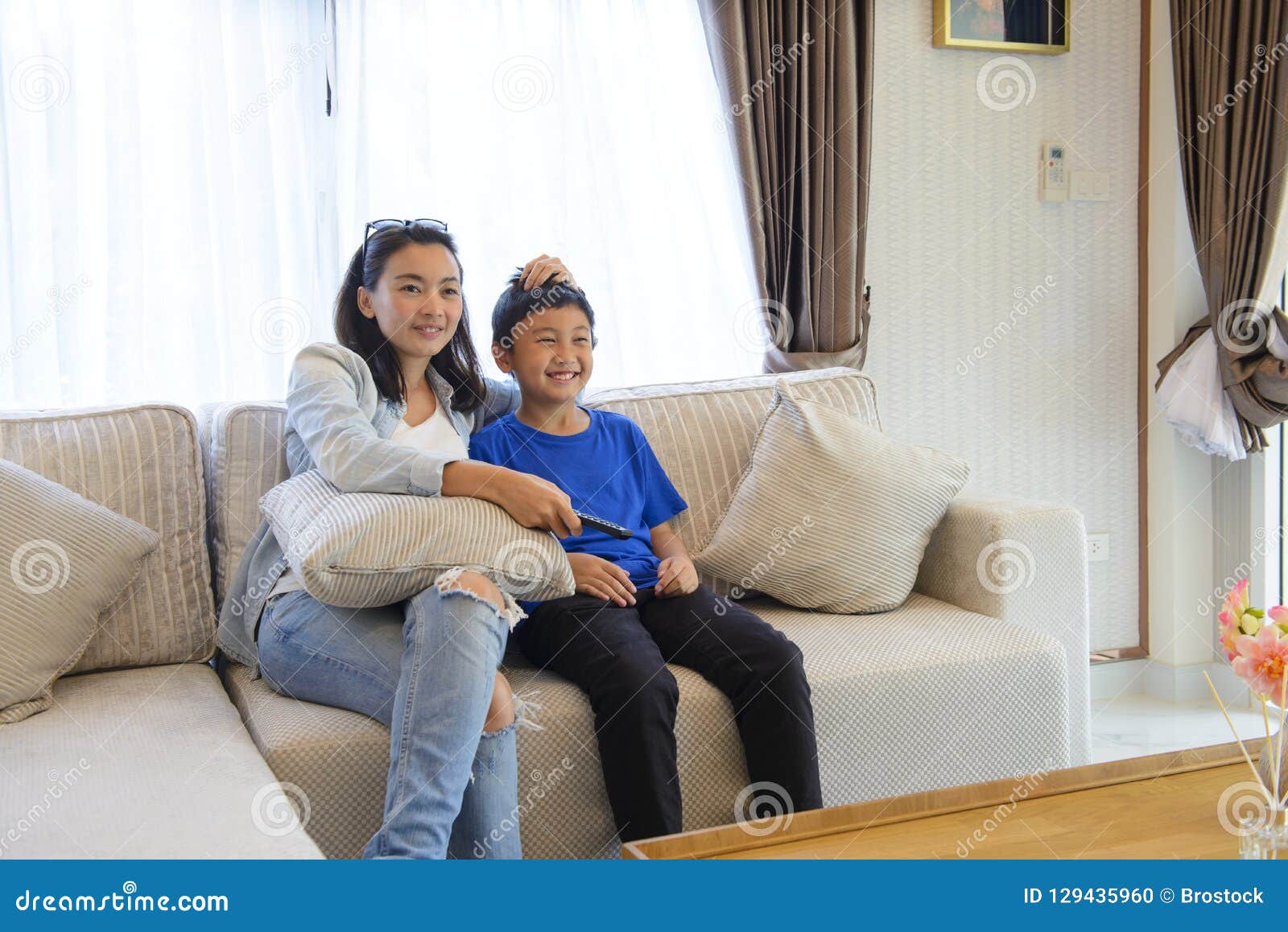 Mother And Son Watching Movie Together On Couch Stock Photo I