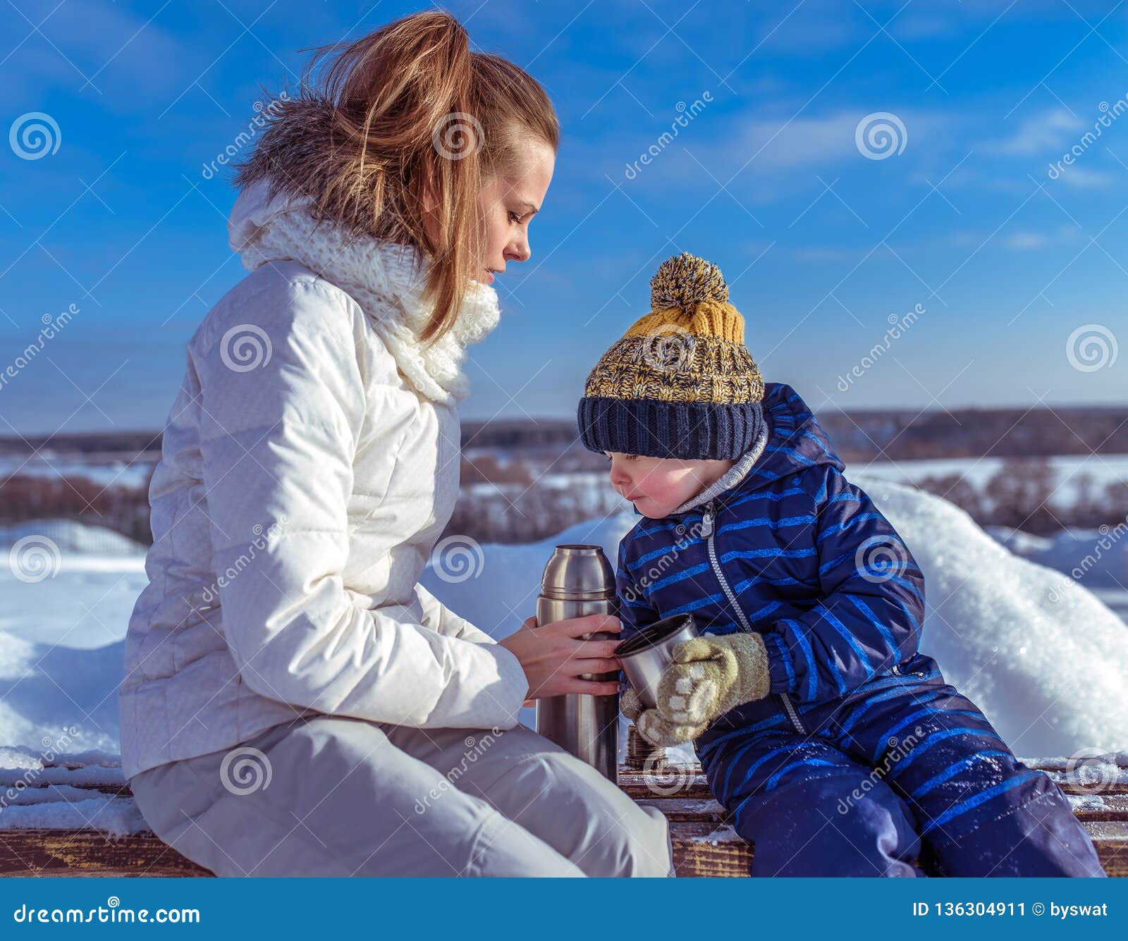 Mother with Son 3 Years Old, Sunny Day in Winter Outside in Park. Sits on a  Bench in the Hands of a Thermos with Hot Tea Stock Image - Image of person