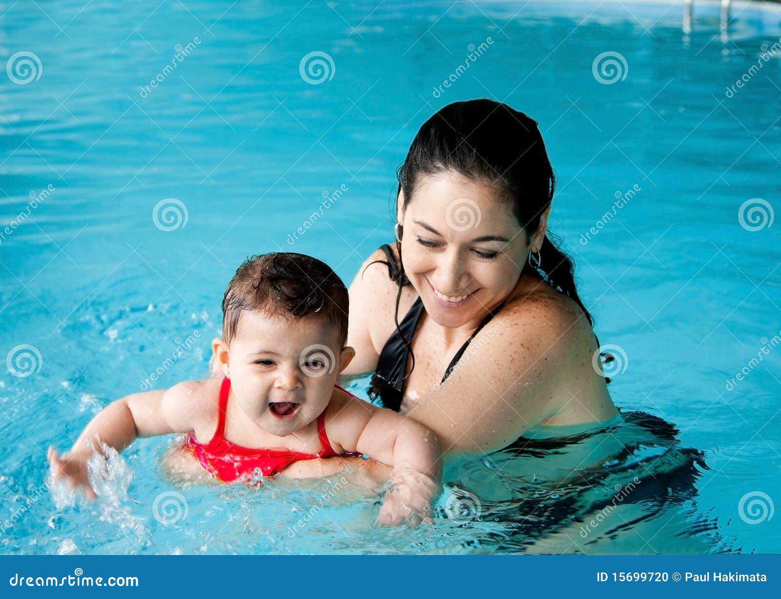 mother teaching baby swimming