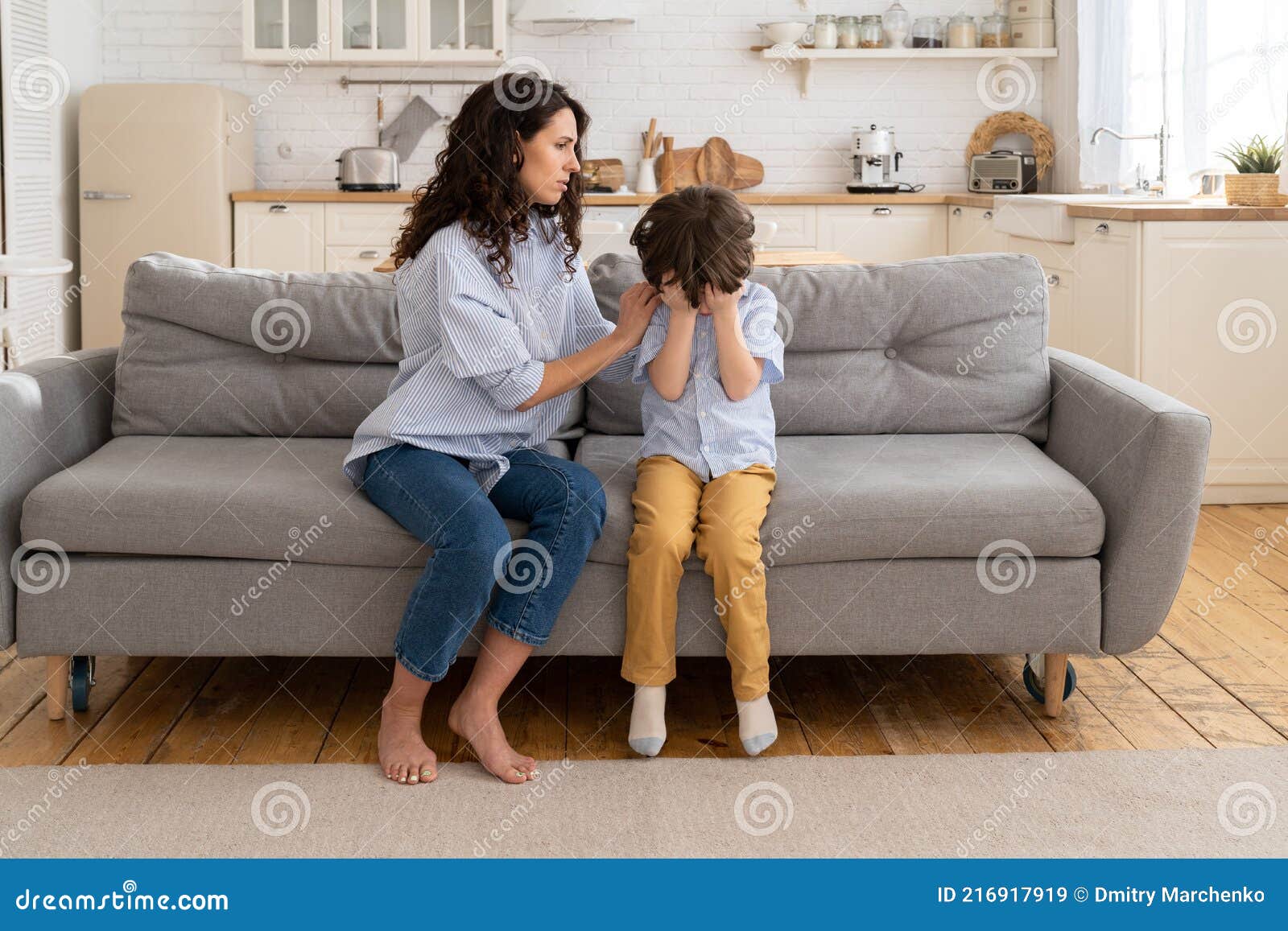 mother trying to distract upset kid. young mom engaging depressed offended son in bad mood by hug