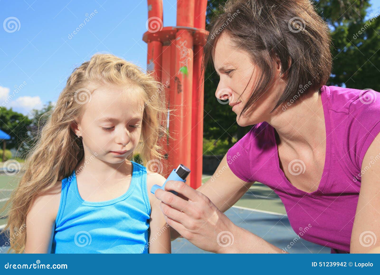 mother using inhaler with her asthmatic daughter