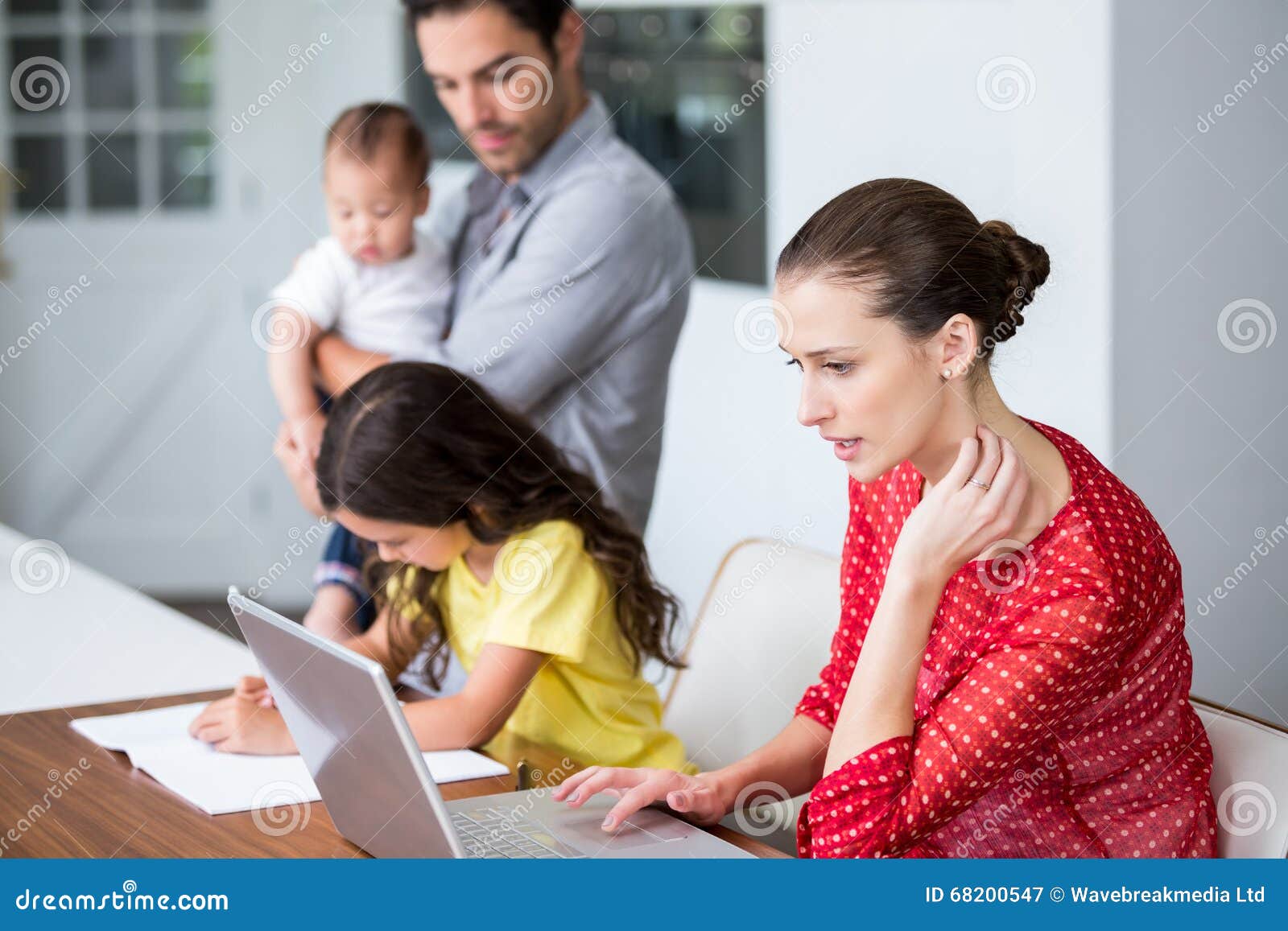 mother working on laptop with daughter studying