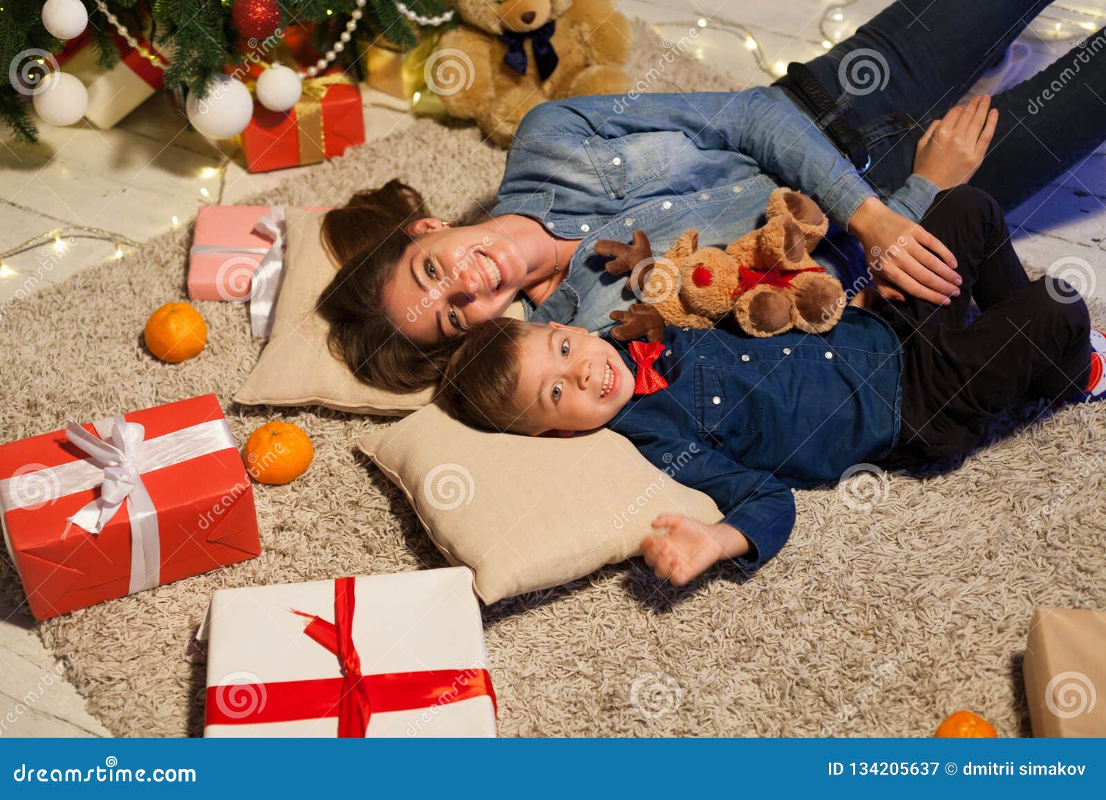 Mother and Young Son are on the Back of a Christmas Tree with Gifts