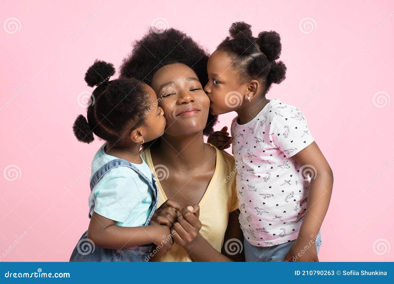 motherhood and family concept. lovely cute two little african girls kids in summer outfits, having fun and kissing their