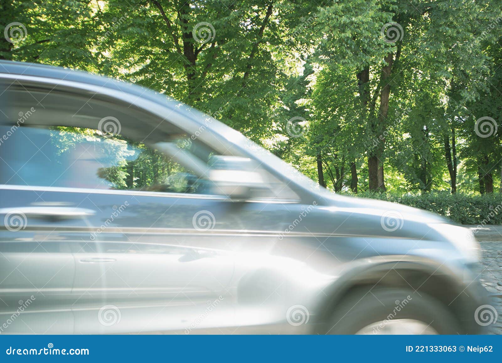 Motion Blurred Fast Moving Car. Background of Green Trees Stock Image