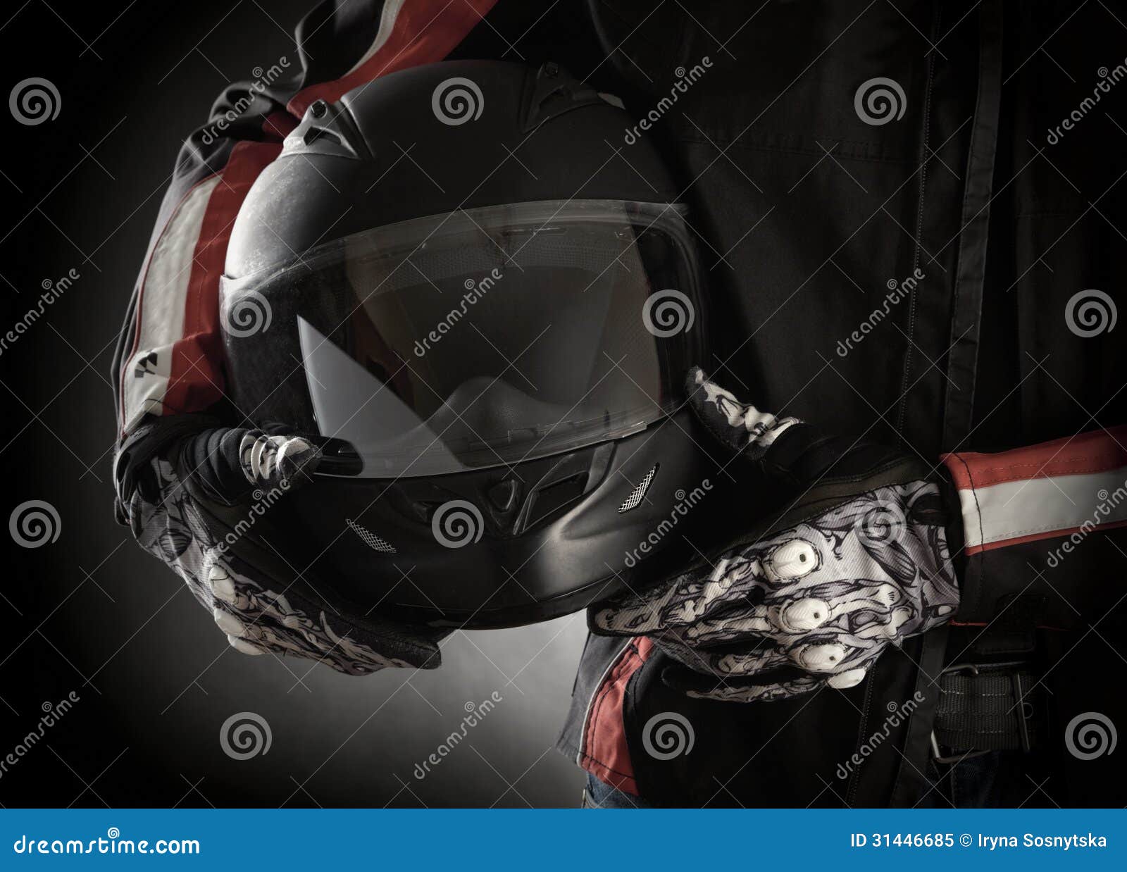 motorcyclist with helmet in his hands. dark background