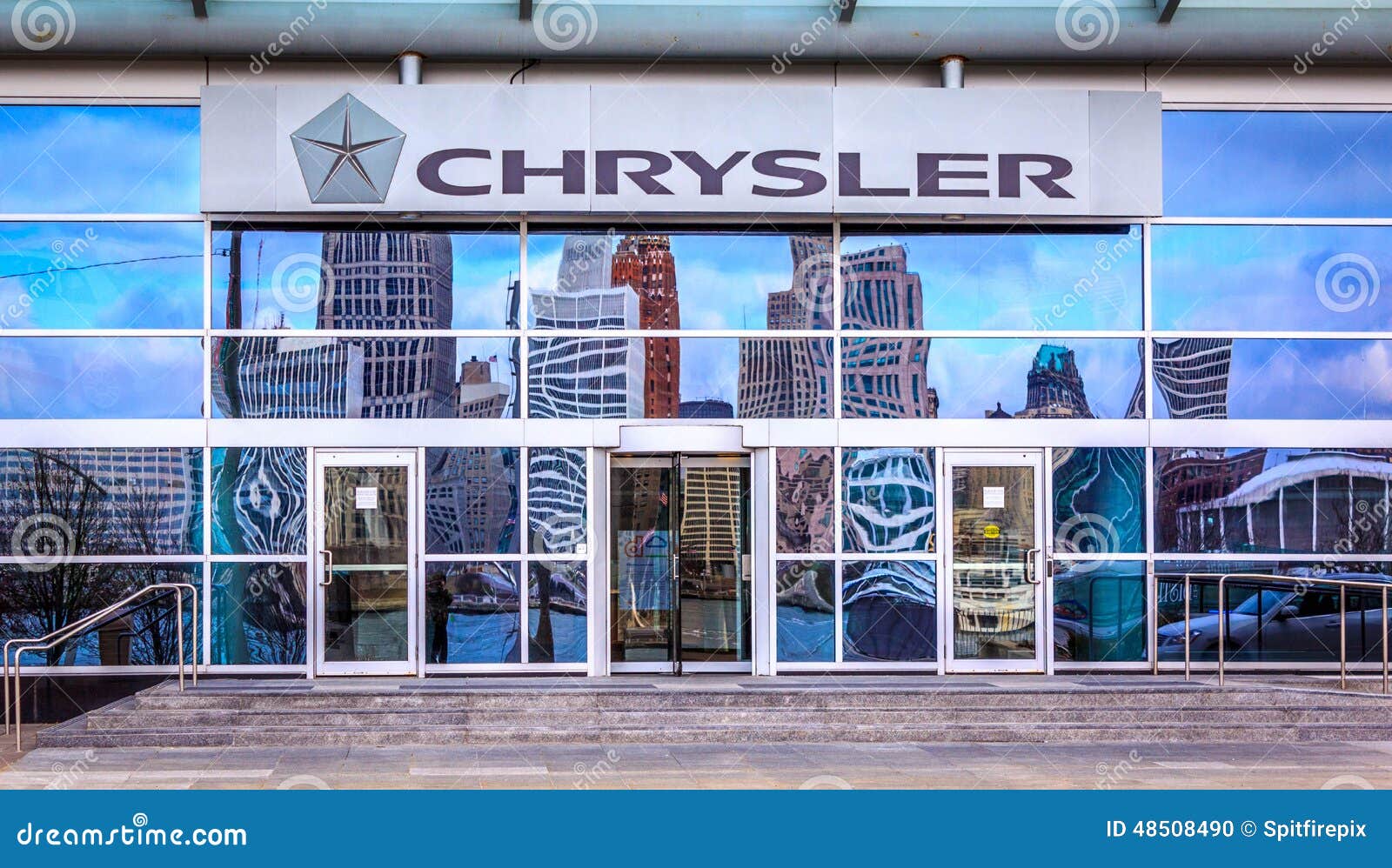 Motoriska stadsreflexioner. Fotografi av Chrysler Kanada högkvarter som lokaliseras i Windsor, Ontario Reflexionen av den motoriska staden, Detroit Michigan, kan ses i fönster
