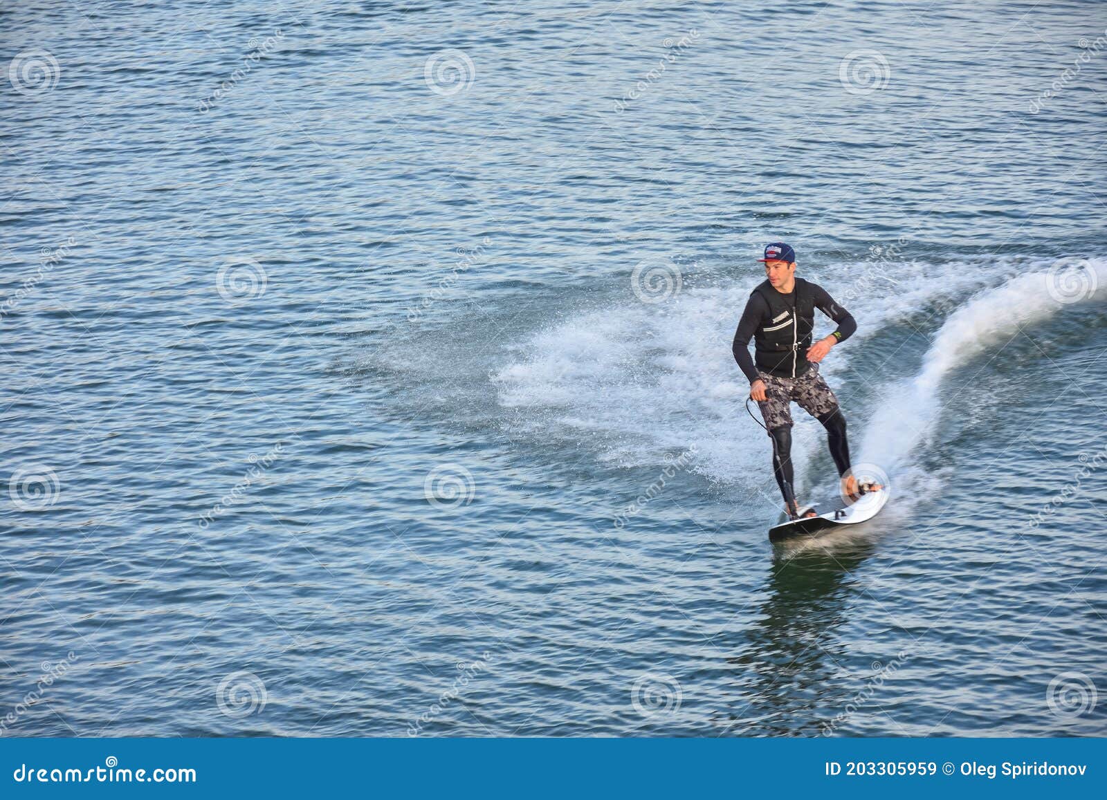 motosurf competitor taking corner at speed making a lot of spray. jet surfing on a water, man riding on jet surfboard. surfer in