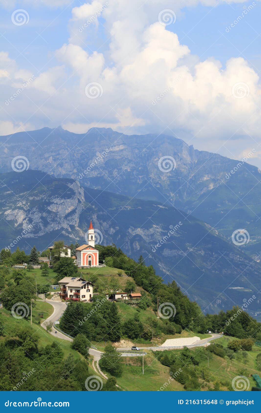 mountain landscape with a small red church in guardia, trentino, italy