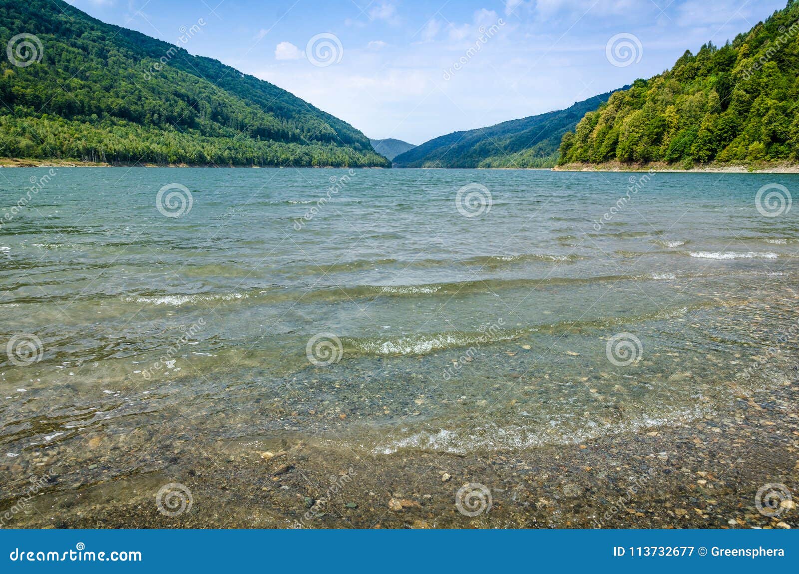 Mountain Lake Shore With Waves In Foreground, Cloudy Sky