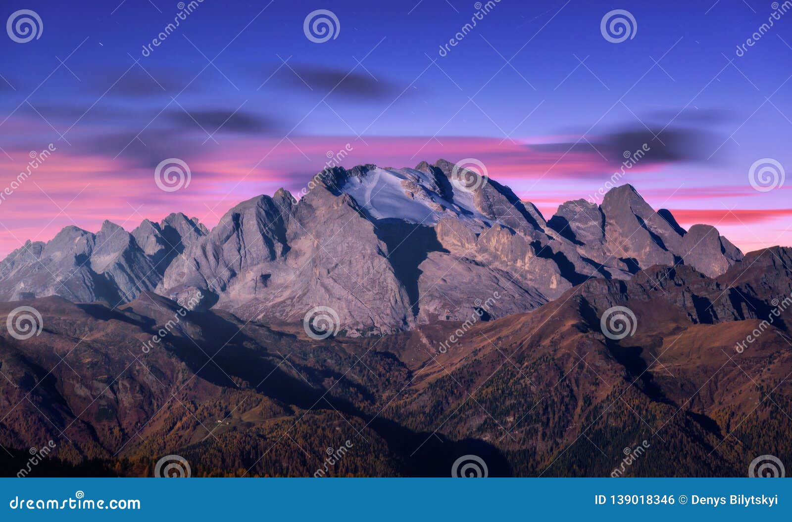 mountain peak lighted by moonlight in autumn at night