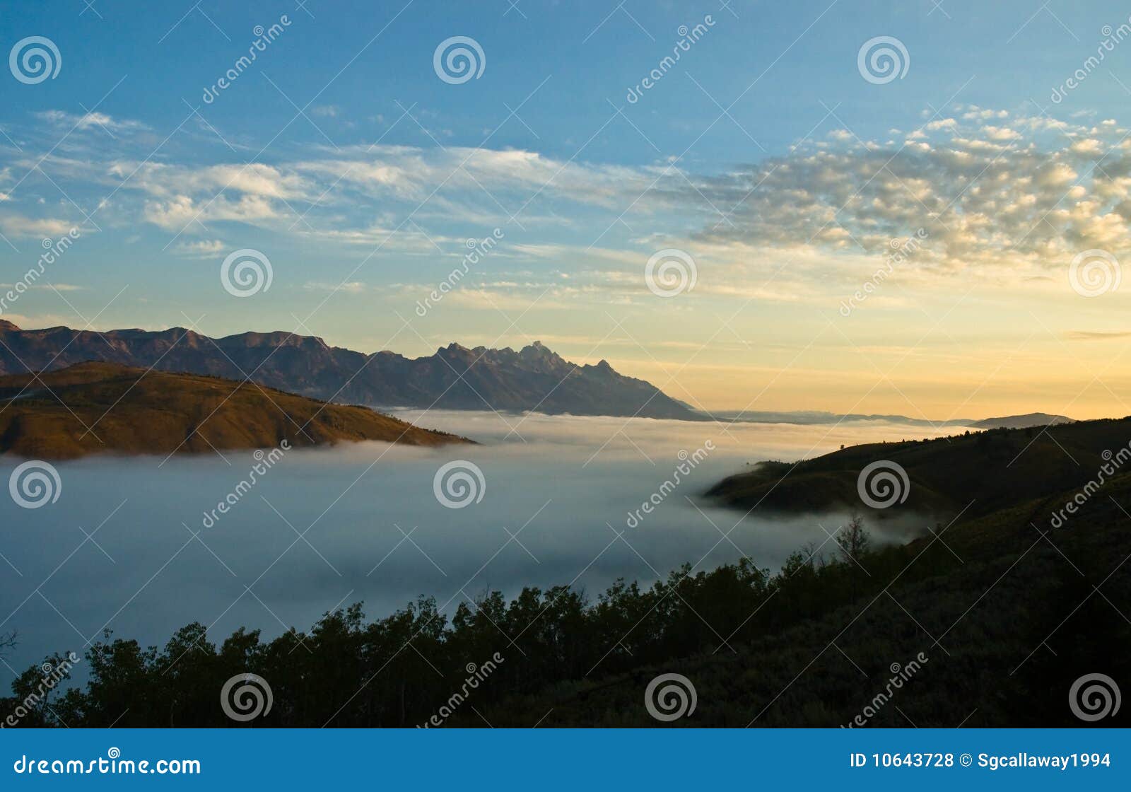 mountain range and a valley of fog at daybreak