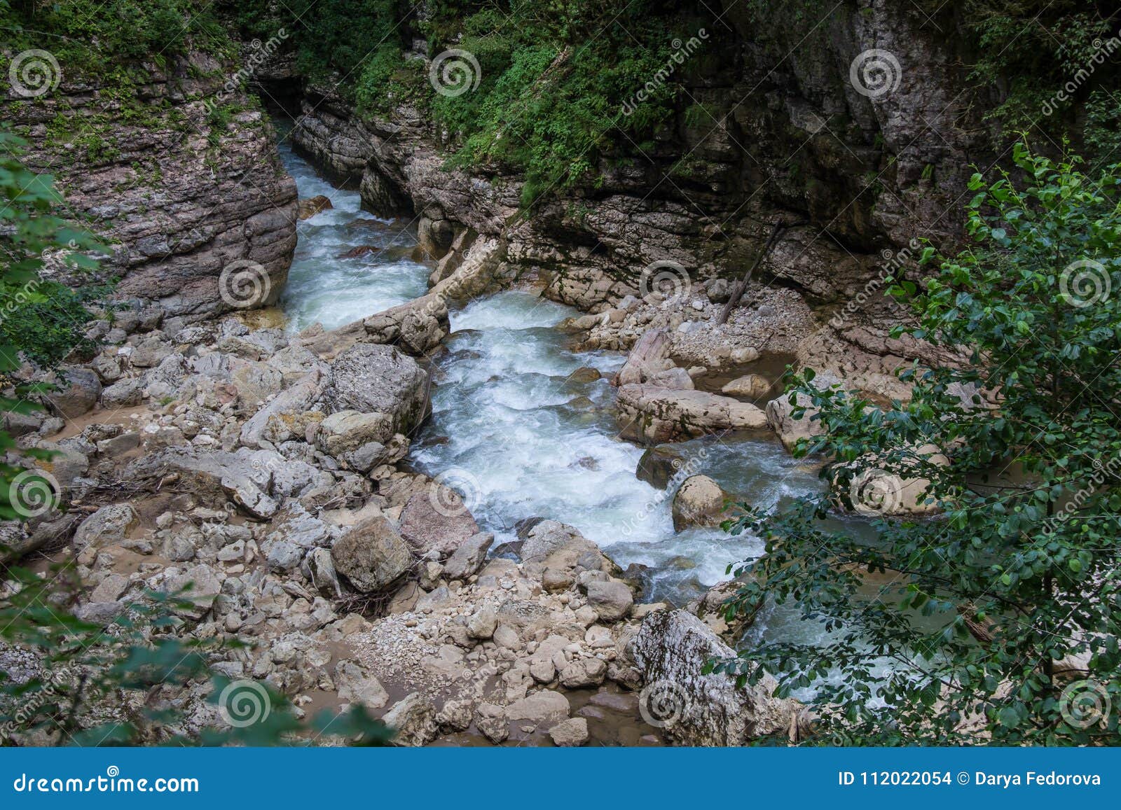 Mountain River Flowing Through The Green Forest And Many Stones Stock