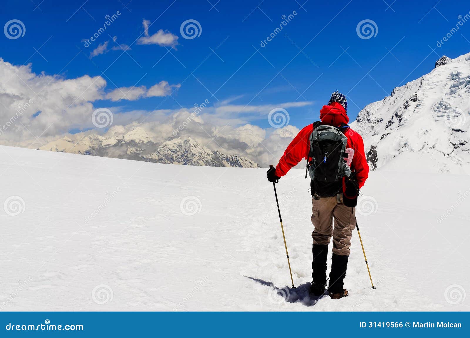 mountain trekker looking at high winter himalayas mountains
