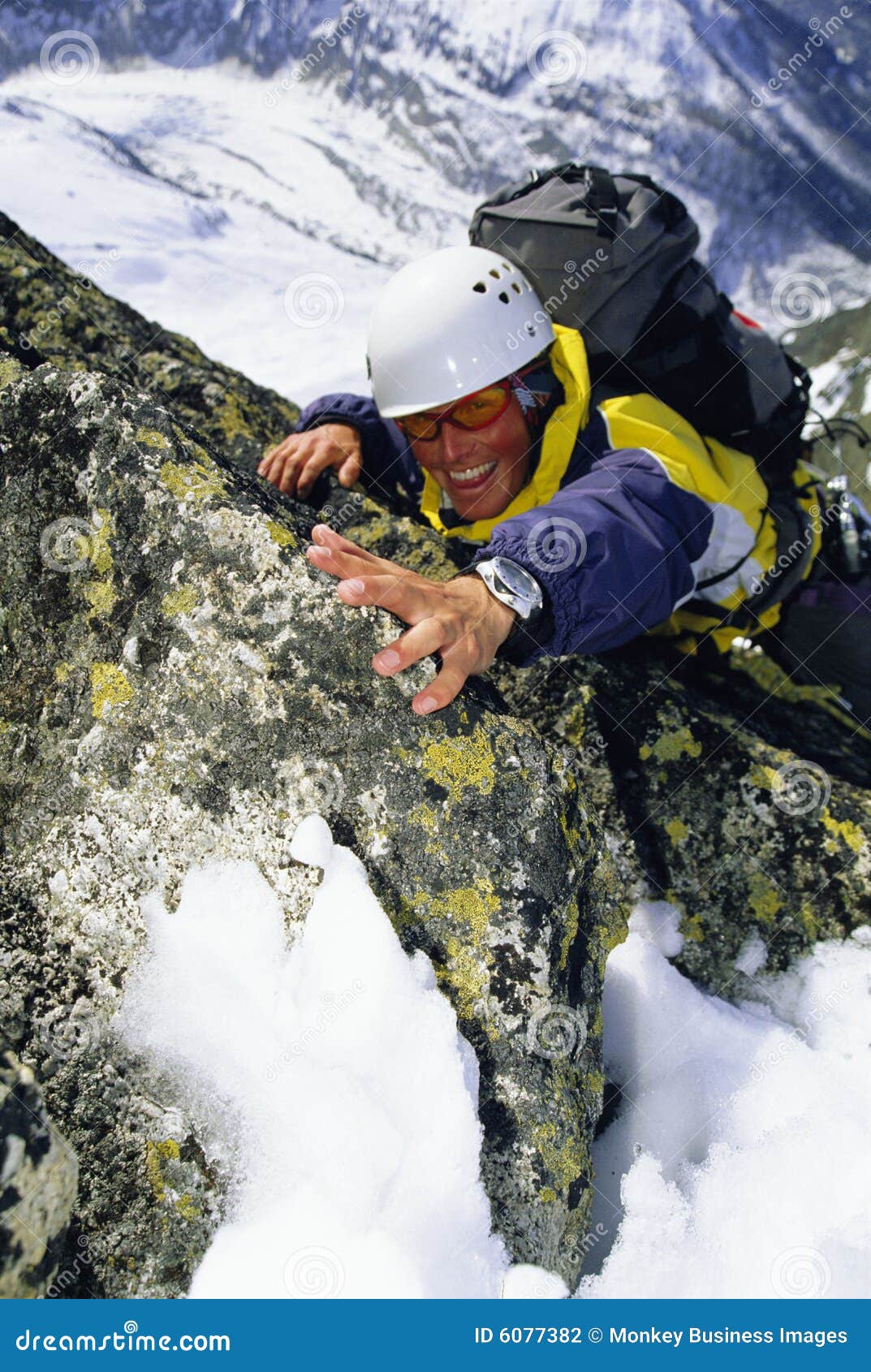 mountaineer climbing snowy rock face