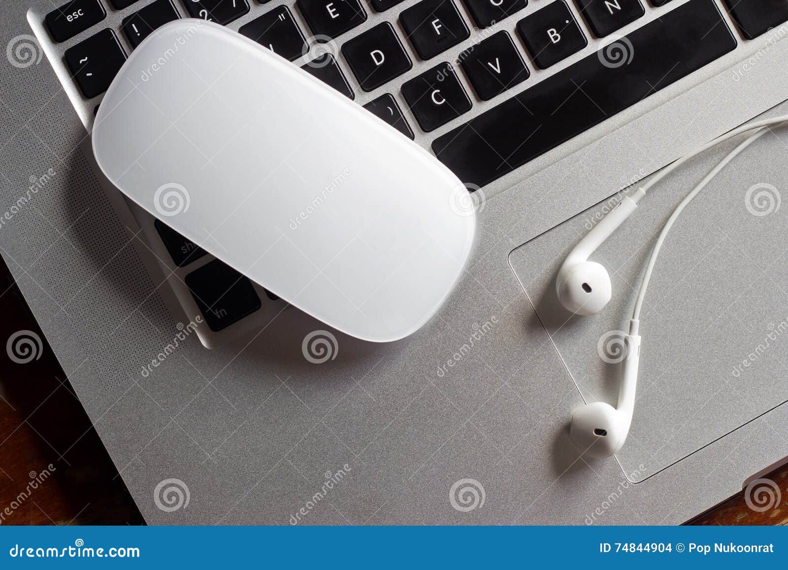 mouse and earphone on laptop computer keyboard