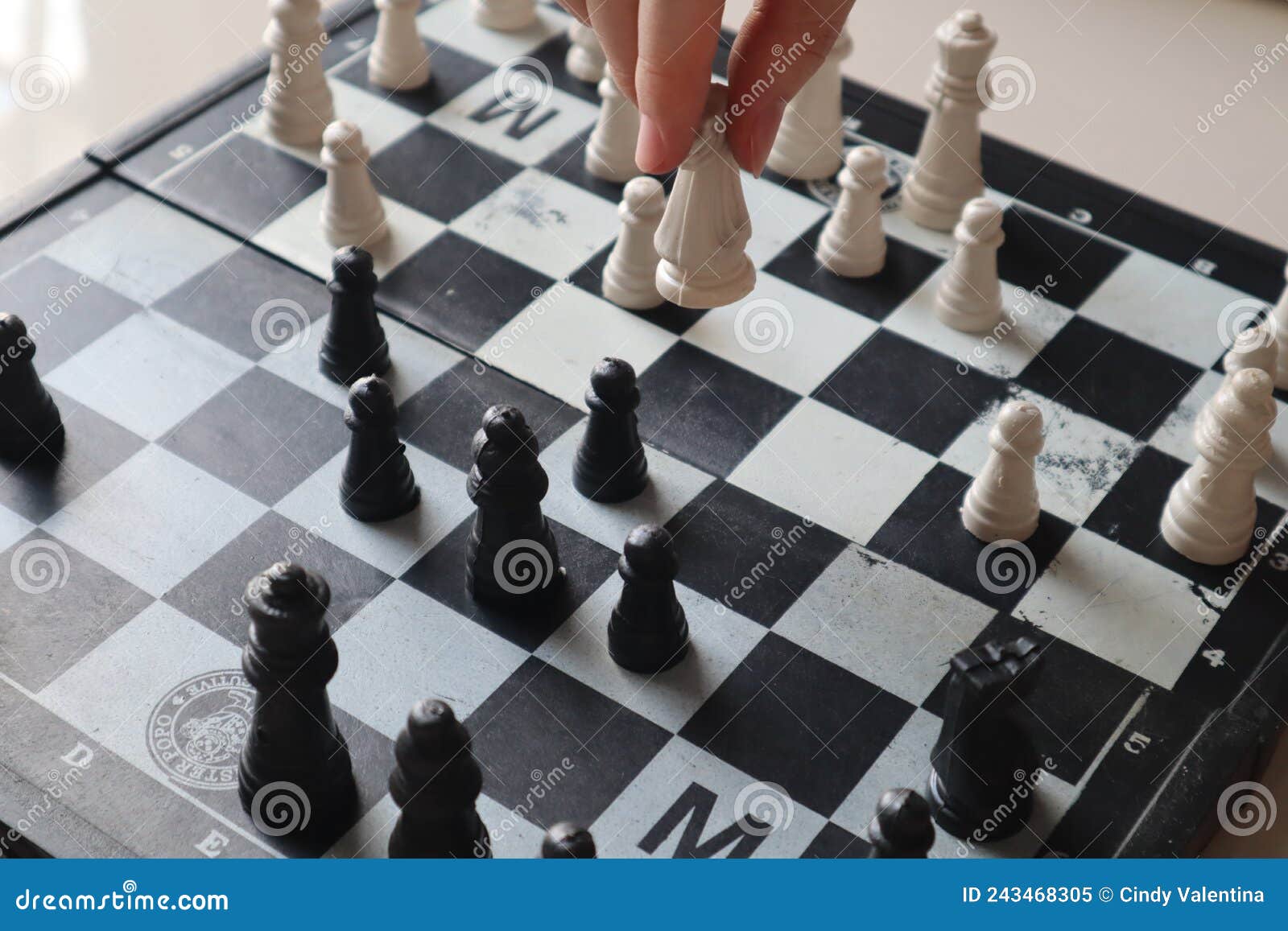 Perto da mulher movendo as peças de xadrez a bordo durante a