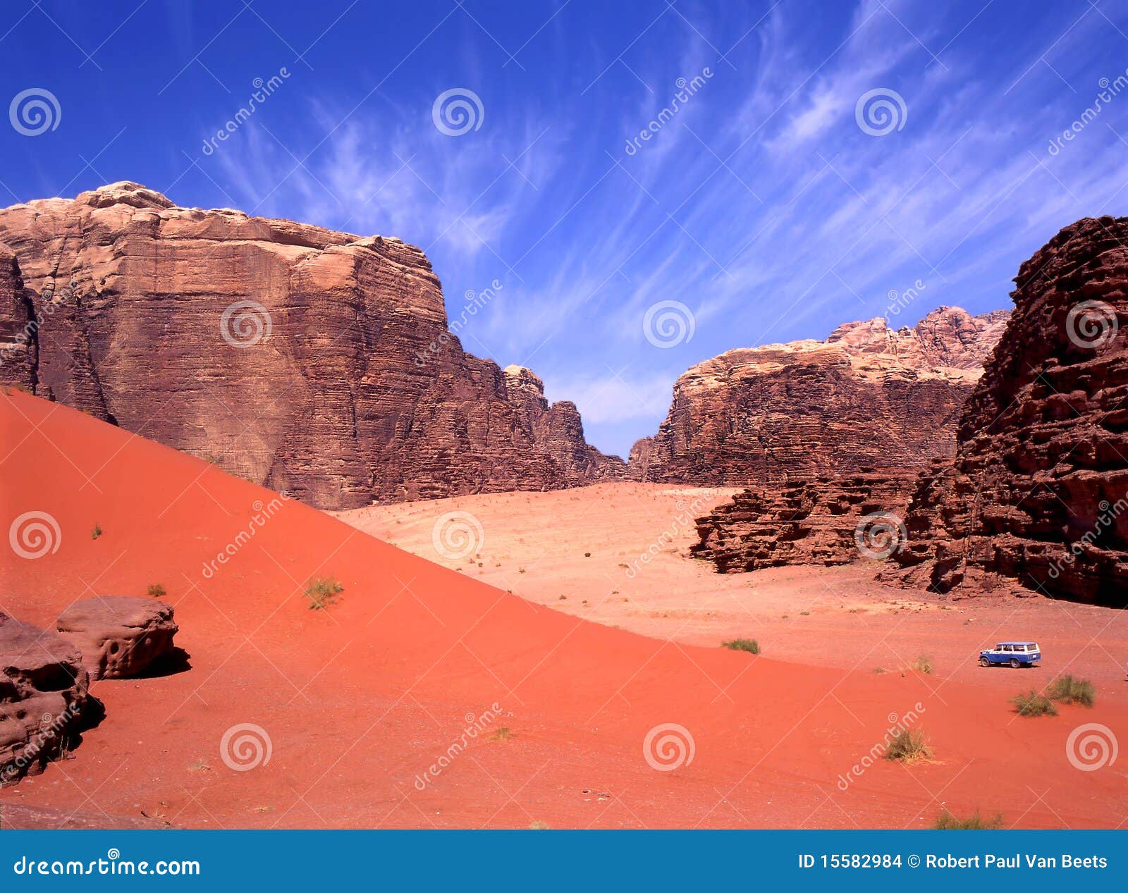 Movimentação de quatro rodas no rum do barranco, Jordão. O céu azul desvanece-se à areia vermelha com os turistas em 4wd em uma excursão neste deserto.