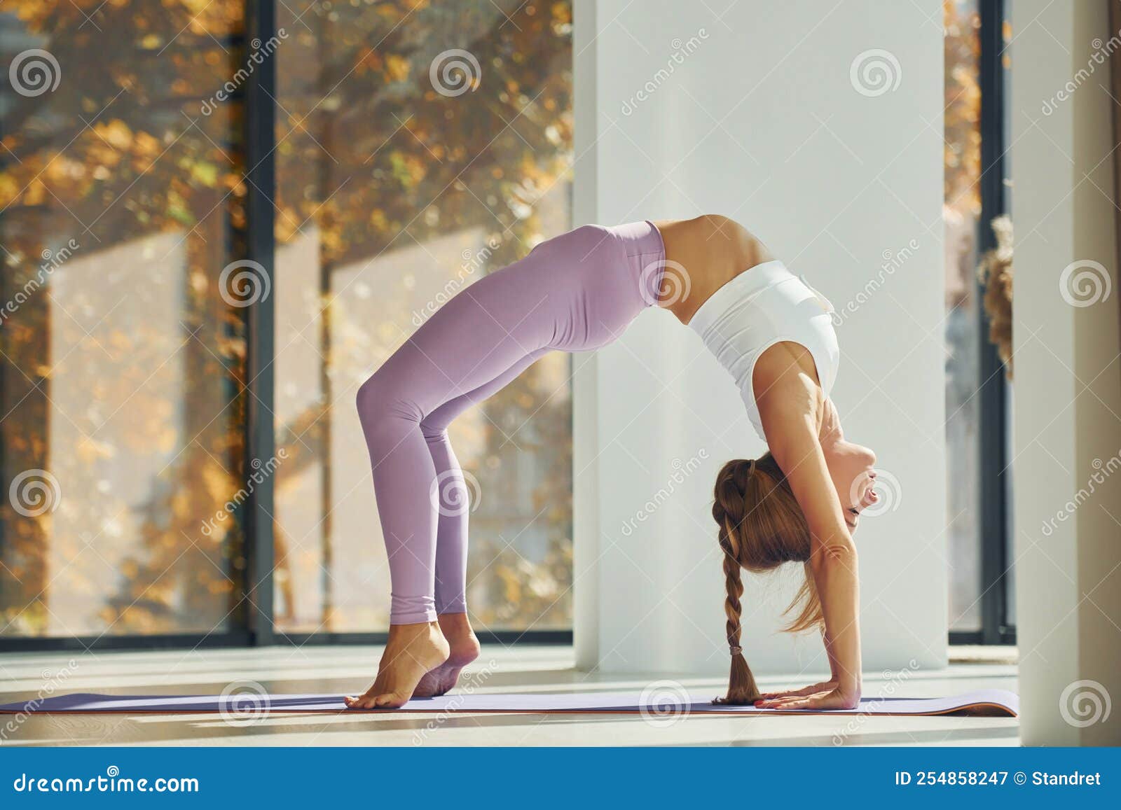 Pose de yoga mujer en ropa deportiva está en el interior