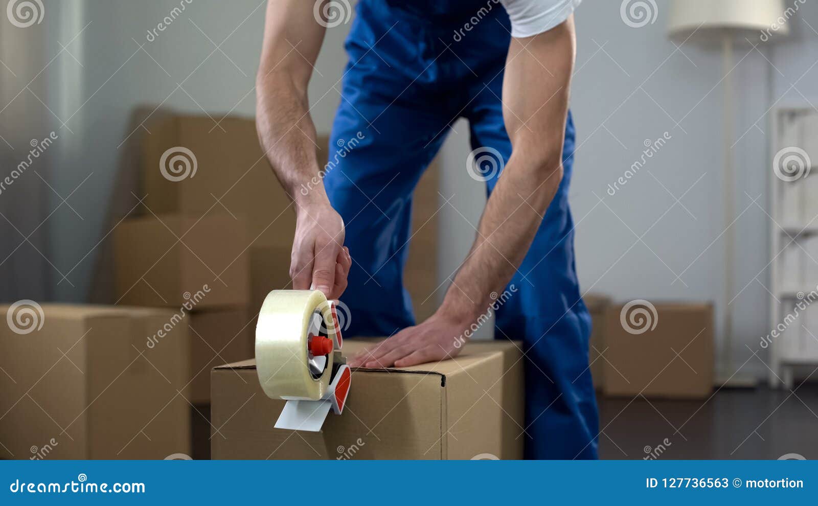 moving company worker packing cardboard boxes, quality delivery services