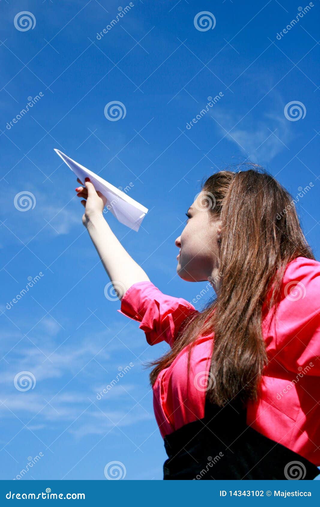 Muchacha caucásica joven con el plano de papel en la mano contra el cielo azul