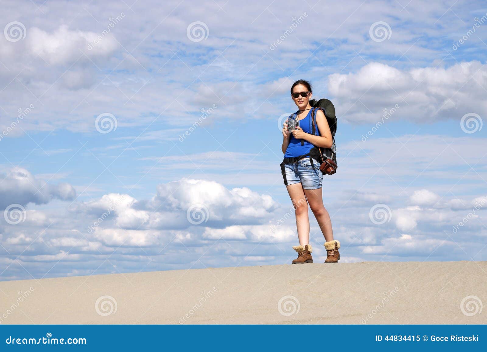 Muchacha con caminar de la cámara. Muchacha con la cámara que camina en desierto