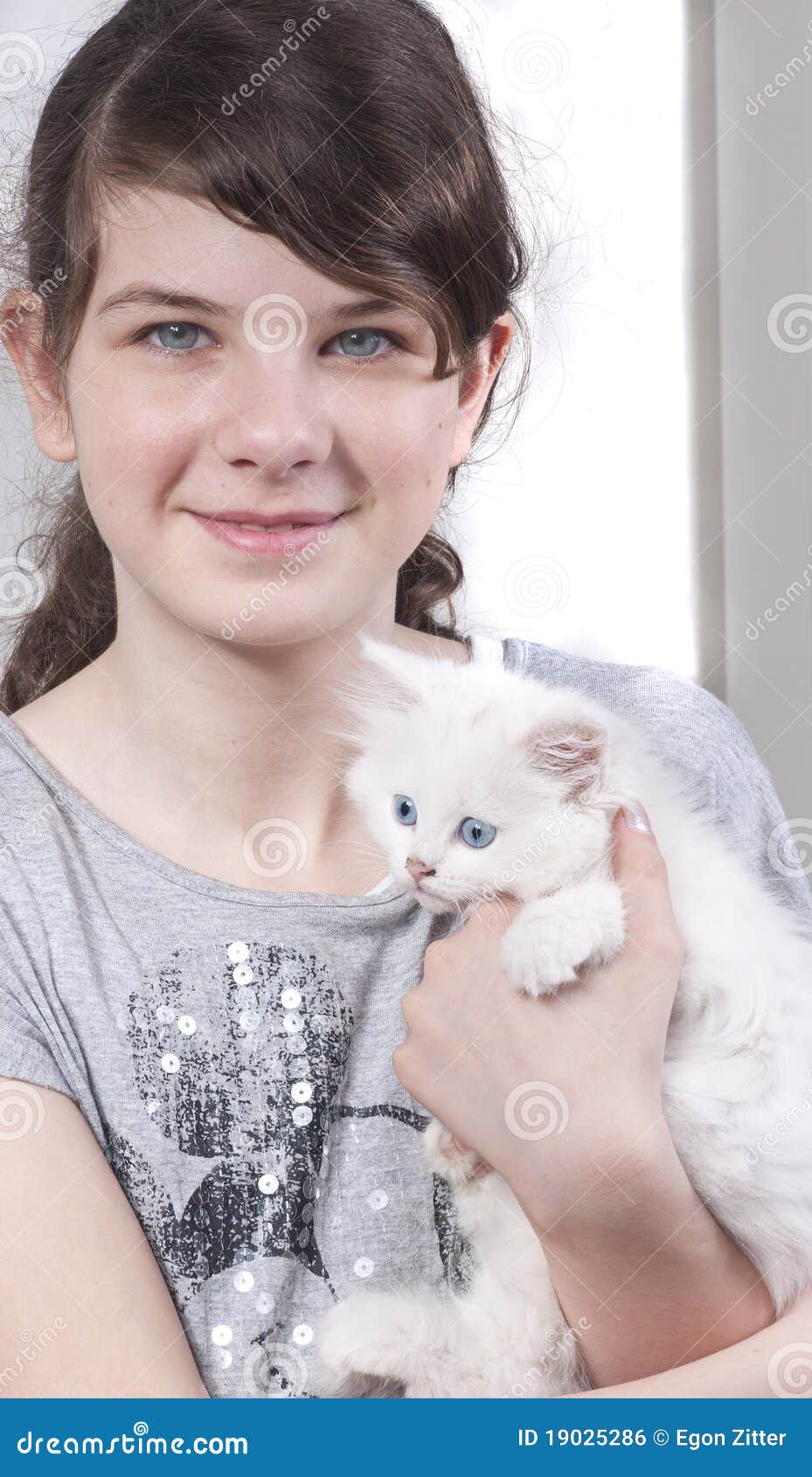 Muchacha con el gatito. Muchacha de ojos azules con el gatito de ojos azules