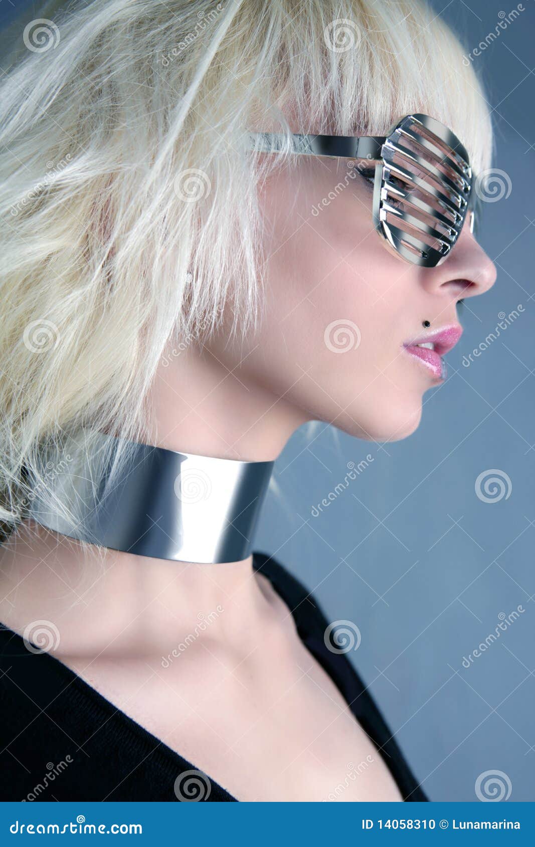 Muchacha de plata futurista de los vidrios de la manera rubia. Fondo de plata futurista del gris de la muchacha de los vidrios de la manera rubia