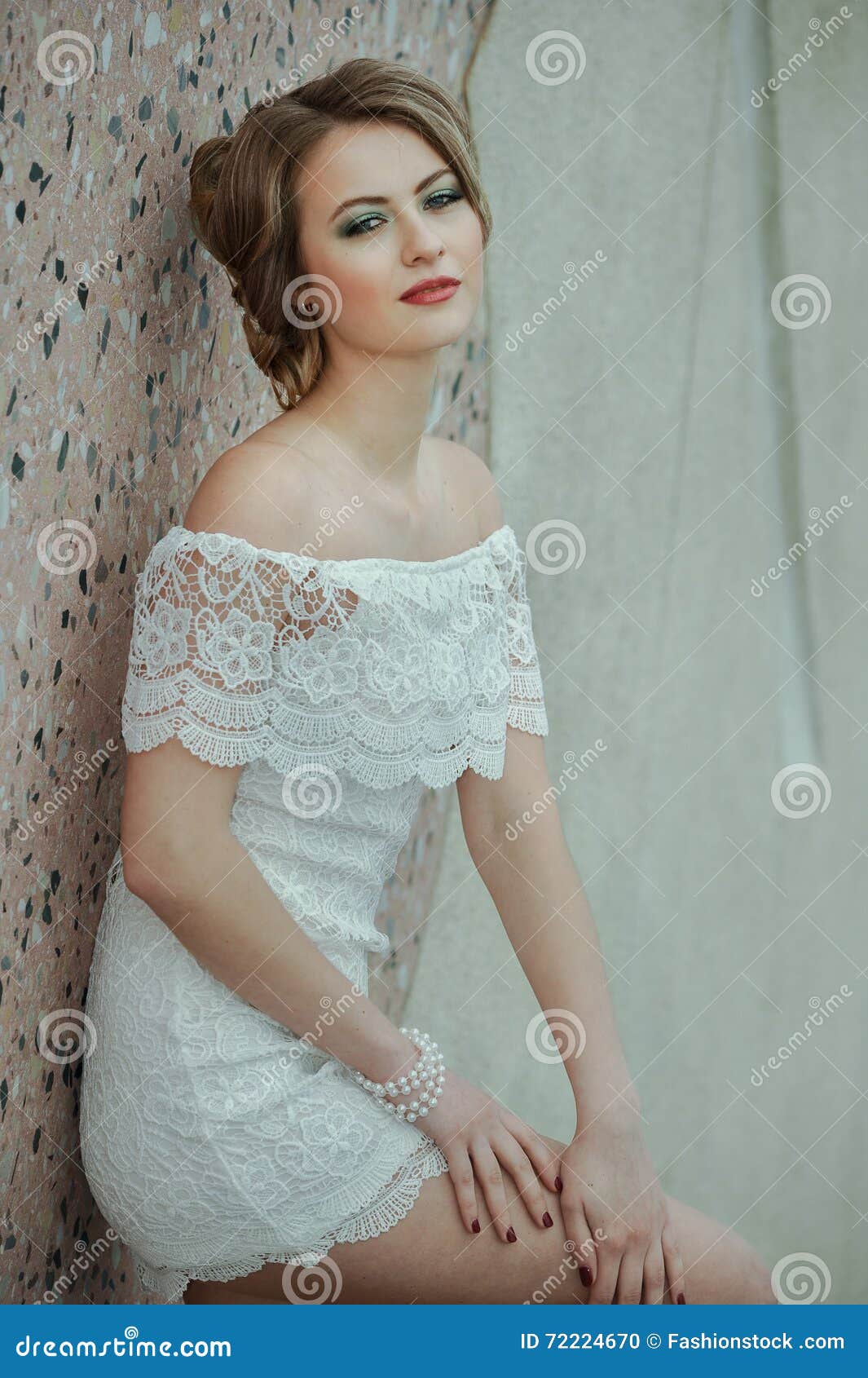 Muchacha Elegante Hermosa Que Presenta En Vestido Blanco Corto Contra Fondo La Pared De Piedra Foto de archivo - Imagen de lifestyle, rubio: