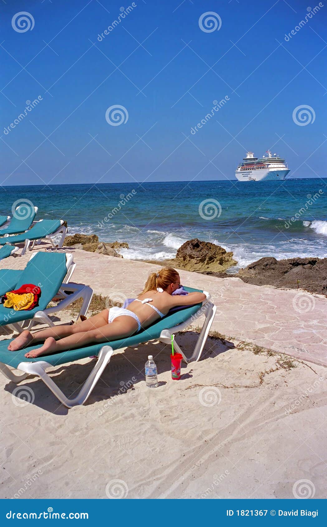 Muchacha en la playa en la isleta de los Cocos con el barco de cruceros