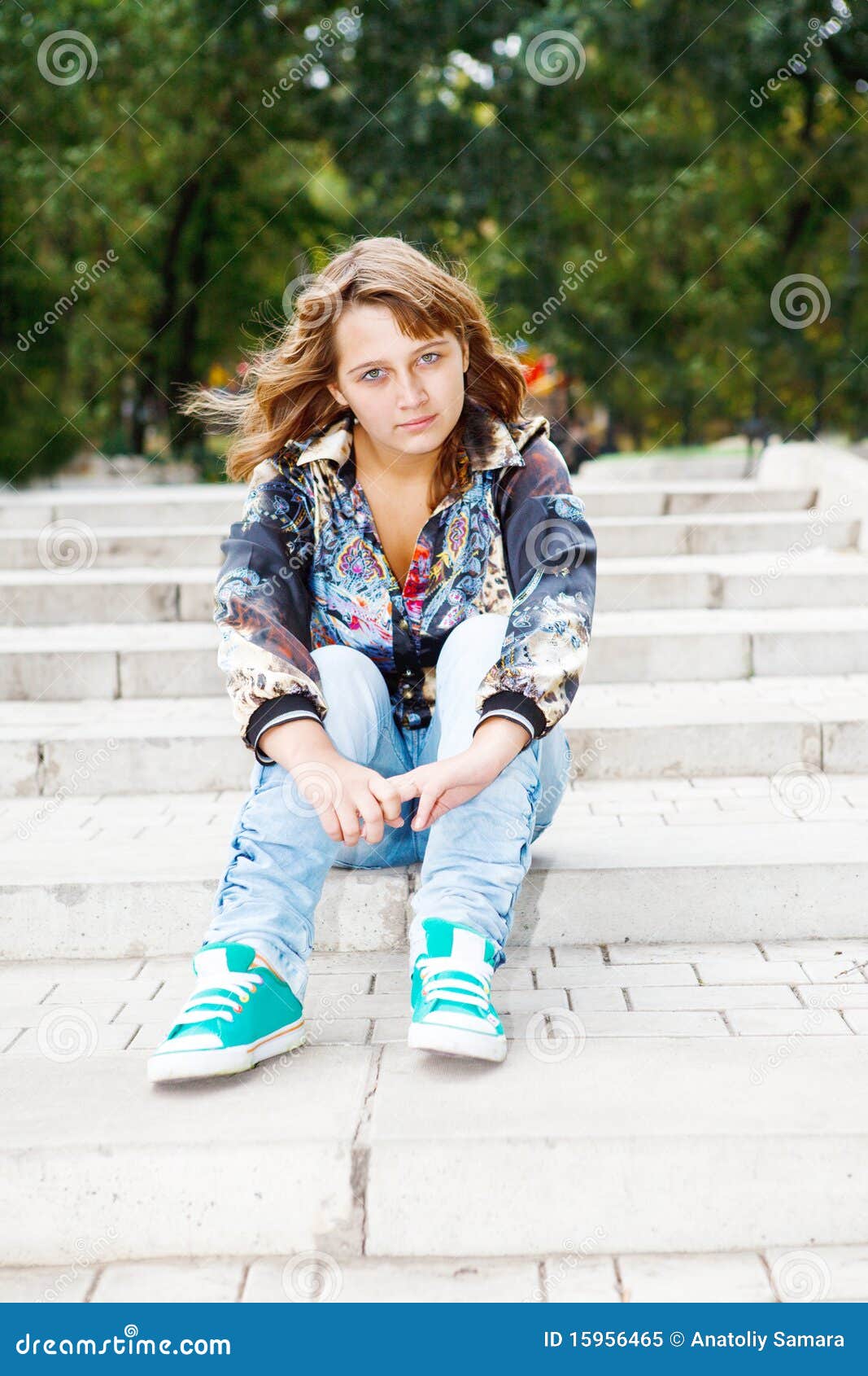 Muchacha que se sienta en las escaleras. Adolescente de moda que se sienta en las escaleras