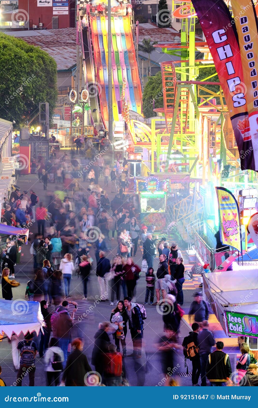 Muchedumbres que gozan del callejón del papel secundario en la demostración real de Ekka Queensland en Brisbane. La gente que disfruta de la diversión de la feria de diversión monta y los juegos en el Ekka Queensland real muestran en Brisbane