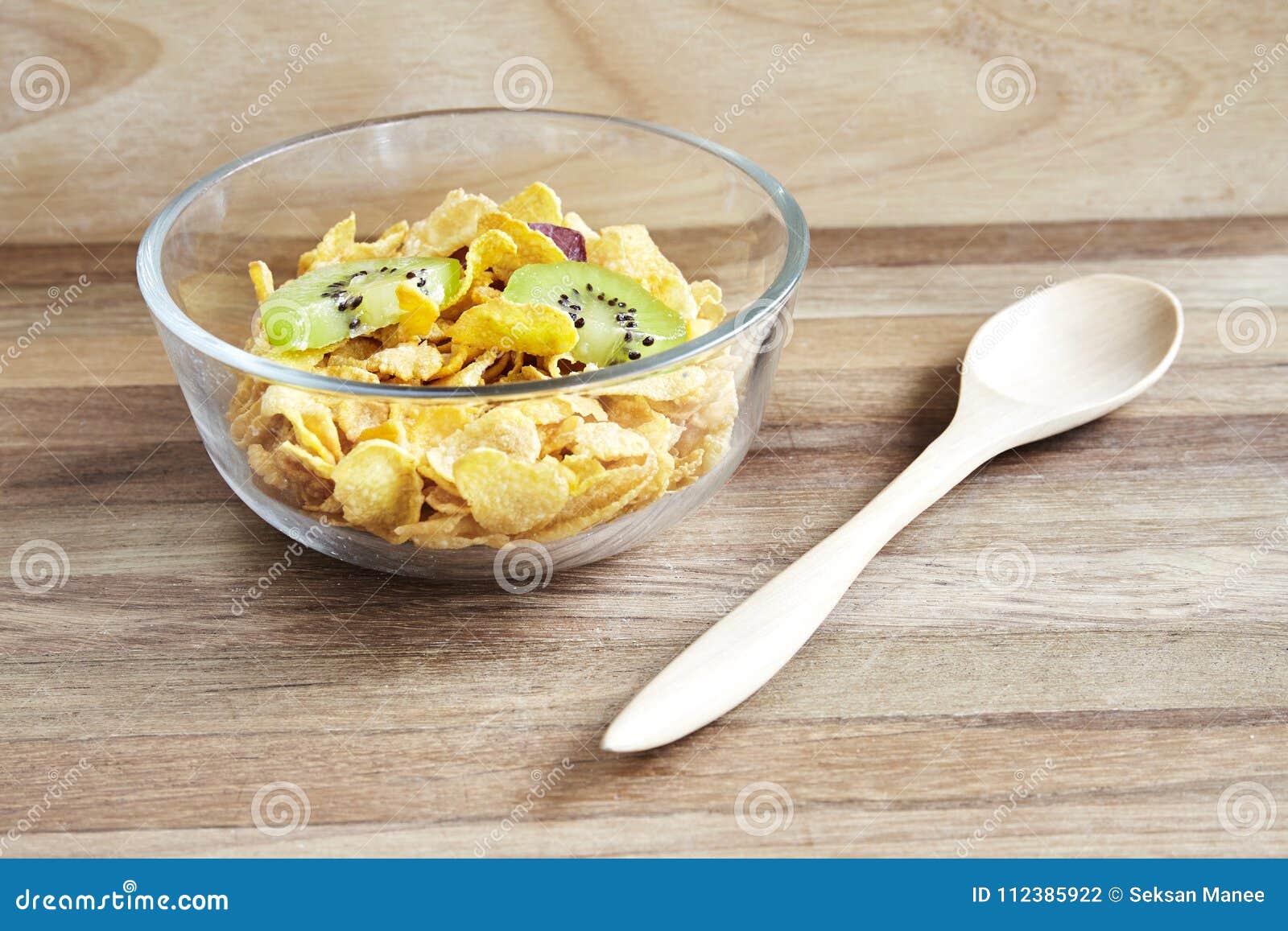 muesli with cornflakes in a glassbowl on rustic wood table