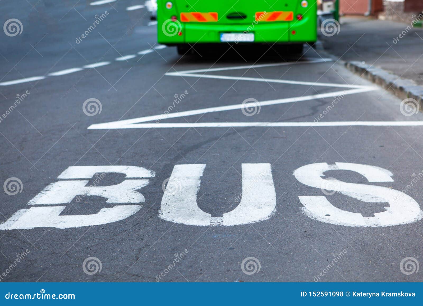 Muestra de la parada de autob?s. Autobús verde cerca de la muestra de la parada de autobús