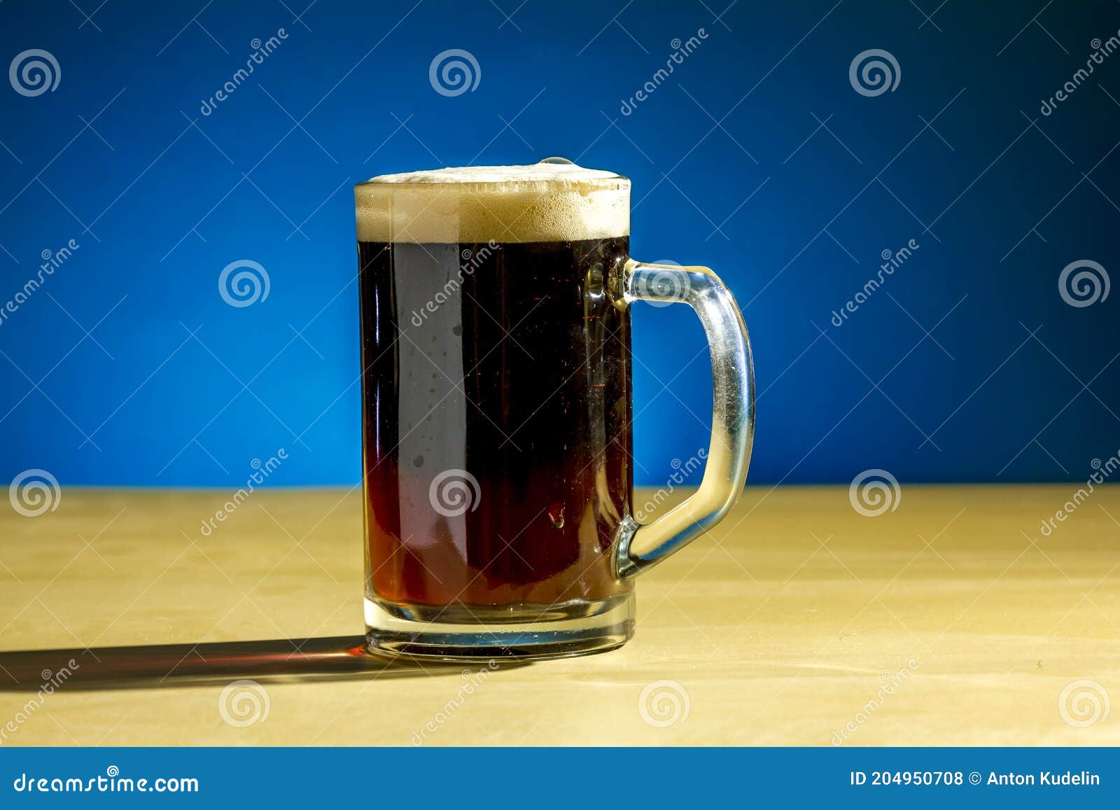 A Mug of Beer Stands on the Table on a Blue Background Stock Photo