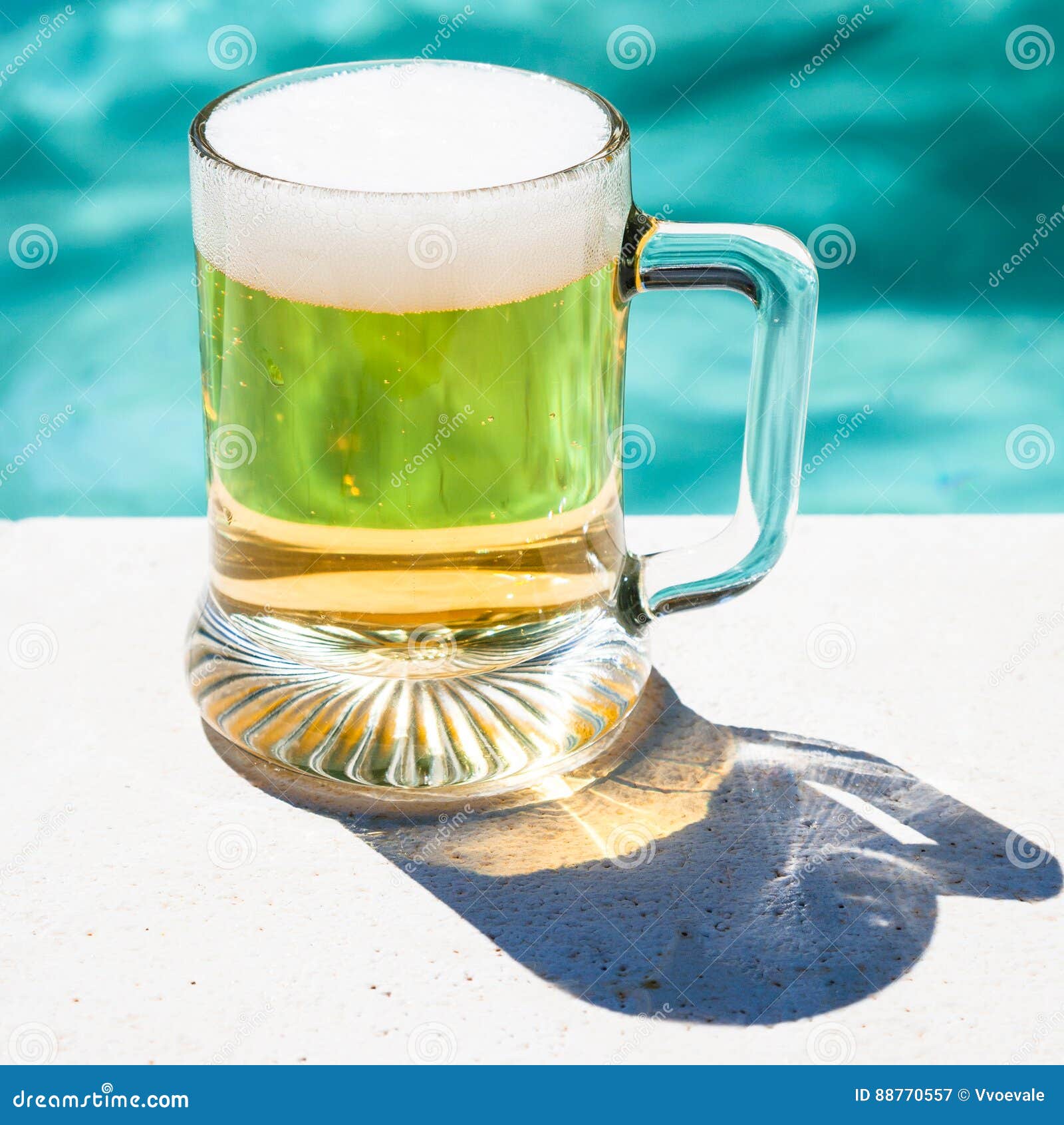 mug of cold beer on the side of the pool