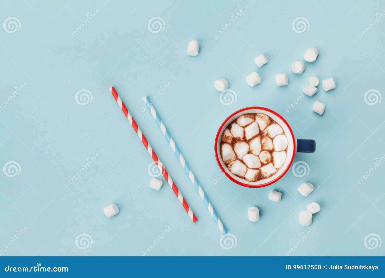 mug of hot cocoa or chocolate and straw on turquoise table top view. flat lay.