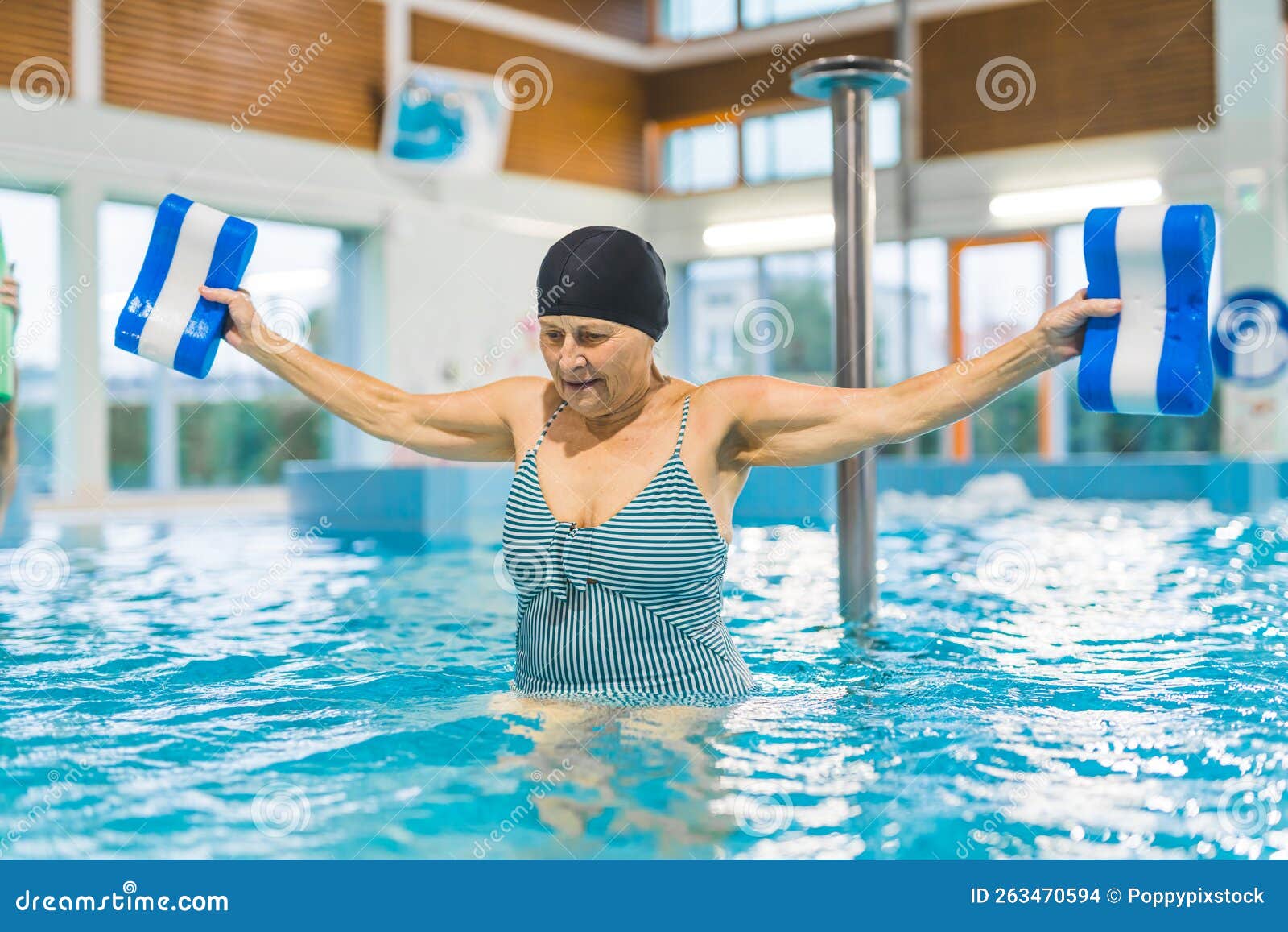 Mujer Caucásica Dedicada De Edad Avanzada Con Traje De Baño a Rayas Y Gorra  De Pelo Negro Con Boyas De Piscina Para Hacer Aqua Eje Foto de archivo -  Imagen de retirado