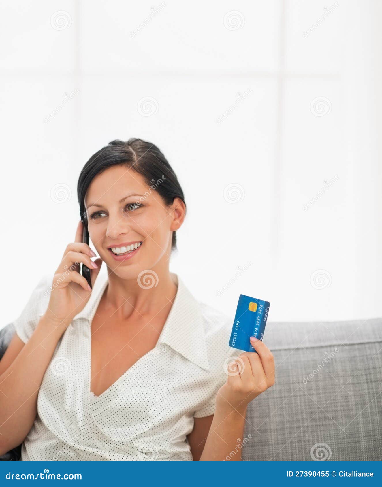 Mujer con el teléfono móvil de la tarjeta de crédito y de discurso. Mujer joven sonriente con el teléfono móvil de la tarjeta de crédito y de discurso