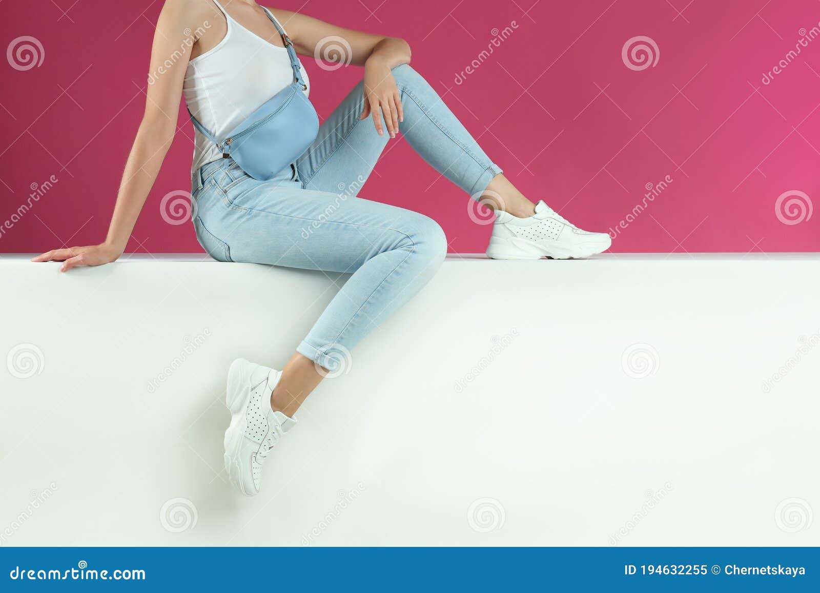 Mujer Con Elegantes Zapatillas Sentada Sobre Fondo De Color Imagen de ...