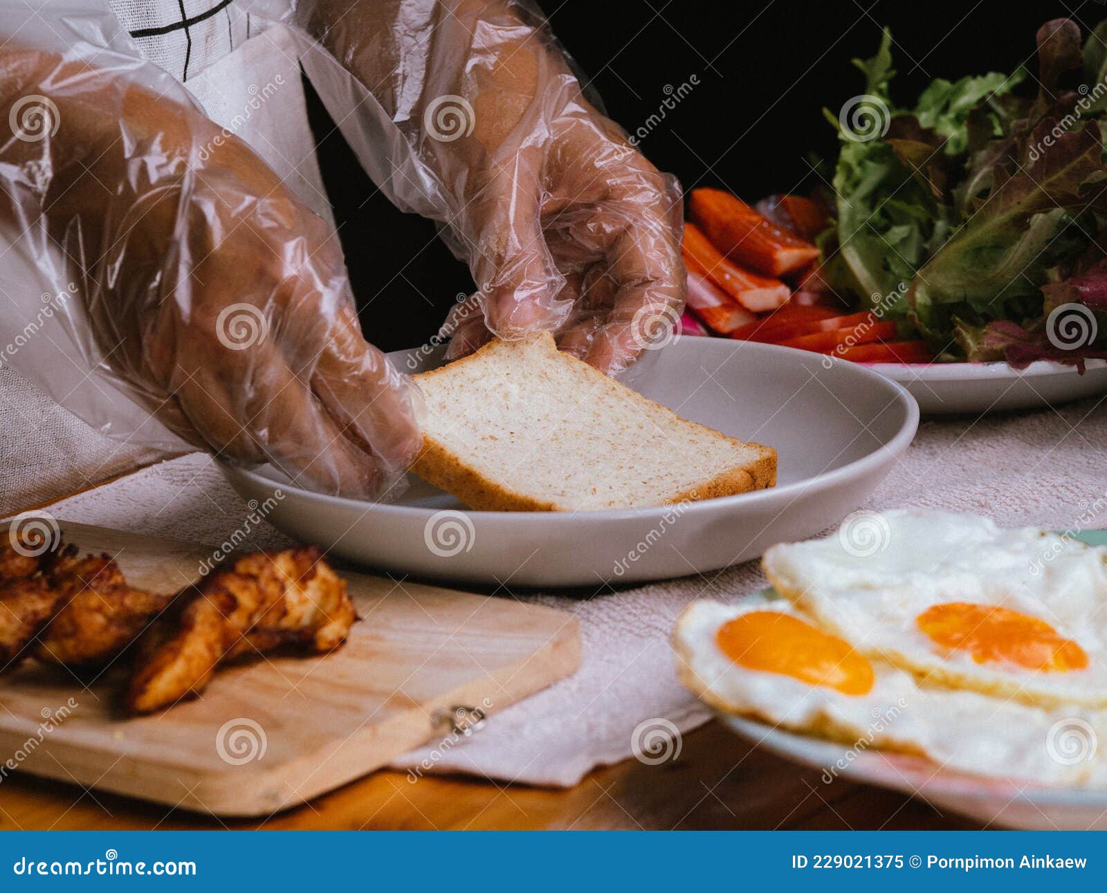 Mujer Con Guantes Cocinando Pan De Trigo Entero Sándwich Con Tomate De  Lechuga De Pollo Frito Coronado Con Mayonesa Y Huevo Frito Imagen de  archivo - Imagen de emparedado, delicioso: 229021375