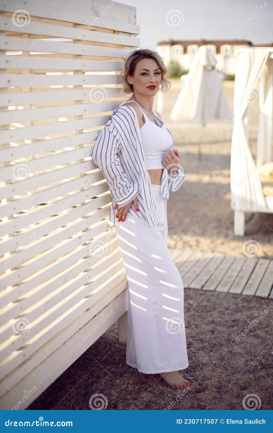 Mujer Con Ropa Blanca Y Gafas De Está De Pie En La Playa Cerca De Imagen de archivo - Imagen de pantalones, 230717507